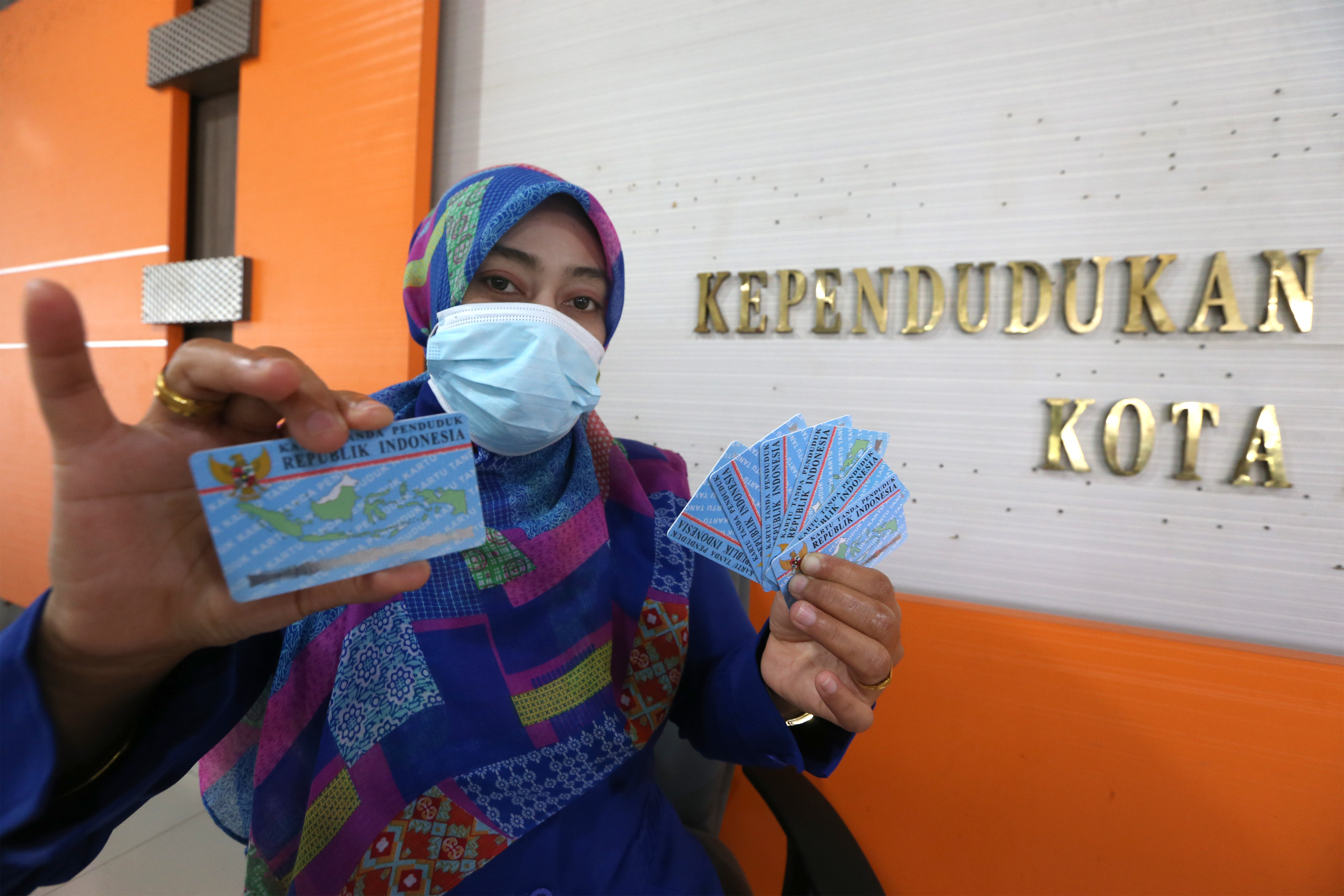 Petugas Dinas Dukcapil Banda Aceh memperlihatkan e-KTP milik warga.