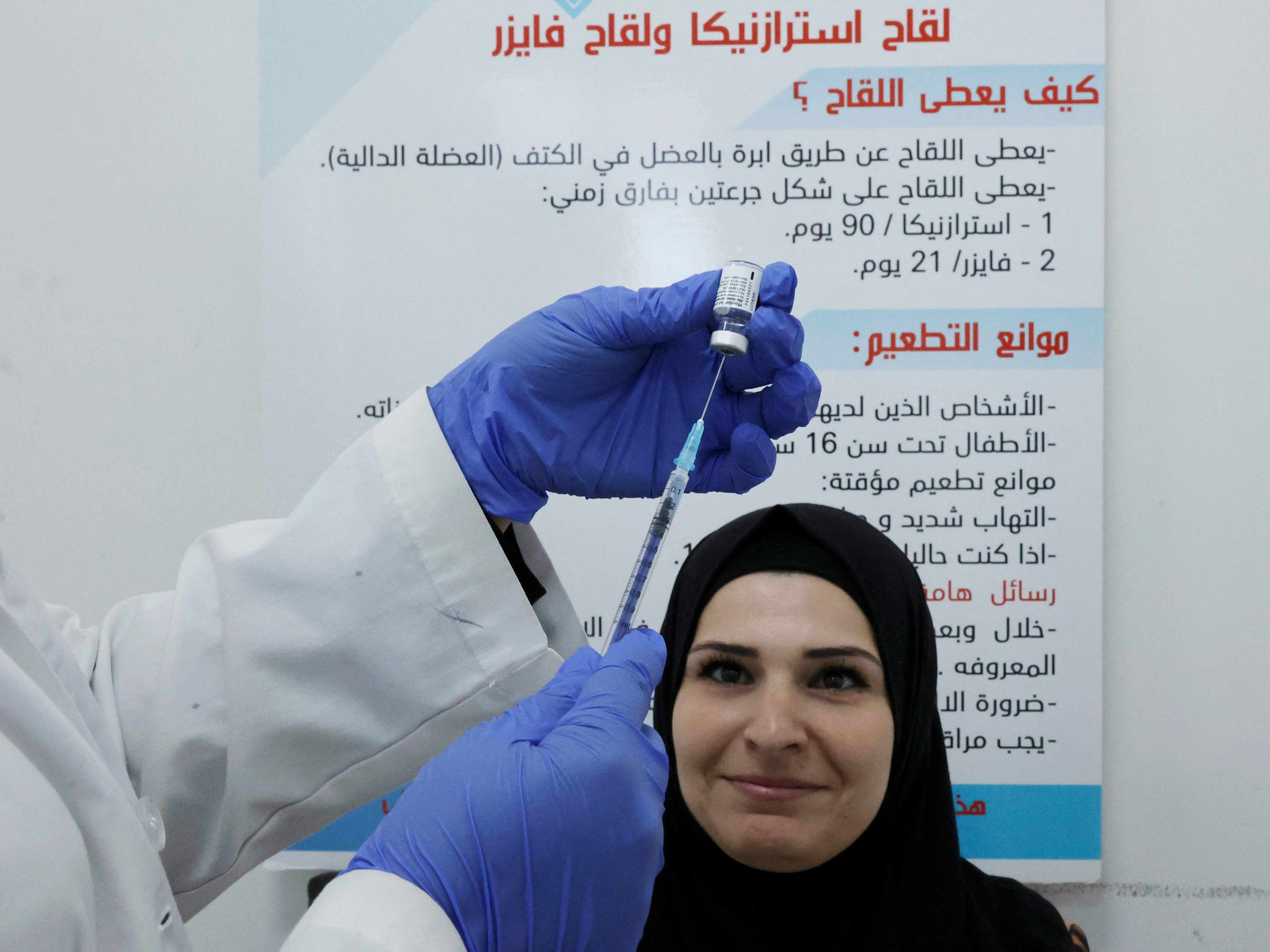 Petugas medis memberikan vaksin covid-19 Pfizer kepada anggota korps akademik dan staf sekolah di kota Hebron, Tepi Barat yang diduduki.