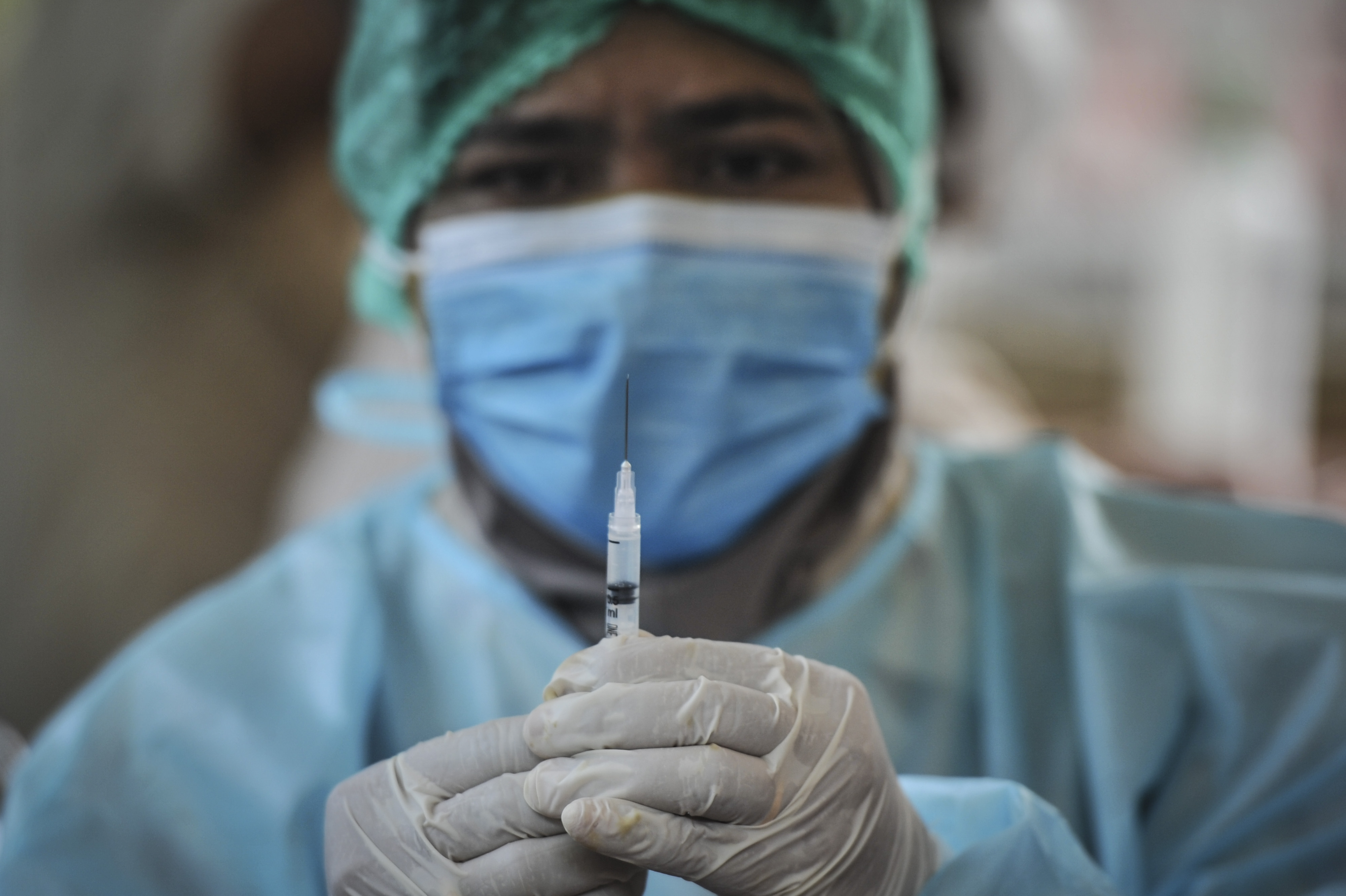 Petugas kesehatan bersiap menyuntikkan vaksin covid-19 kepada warga di wilayah Jakarta.