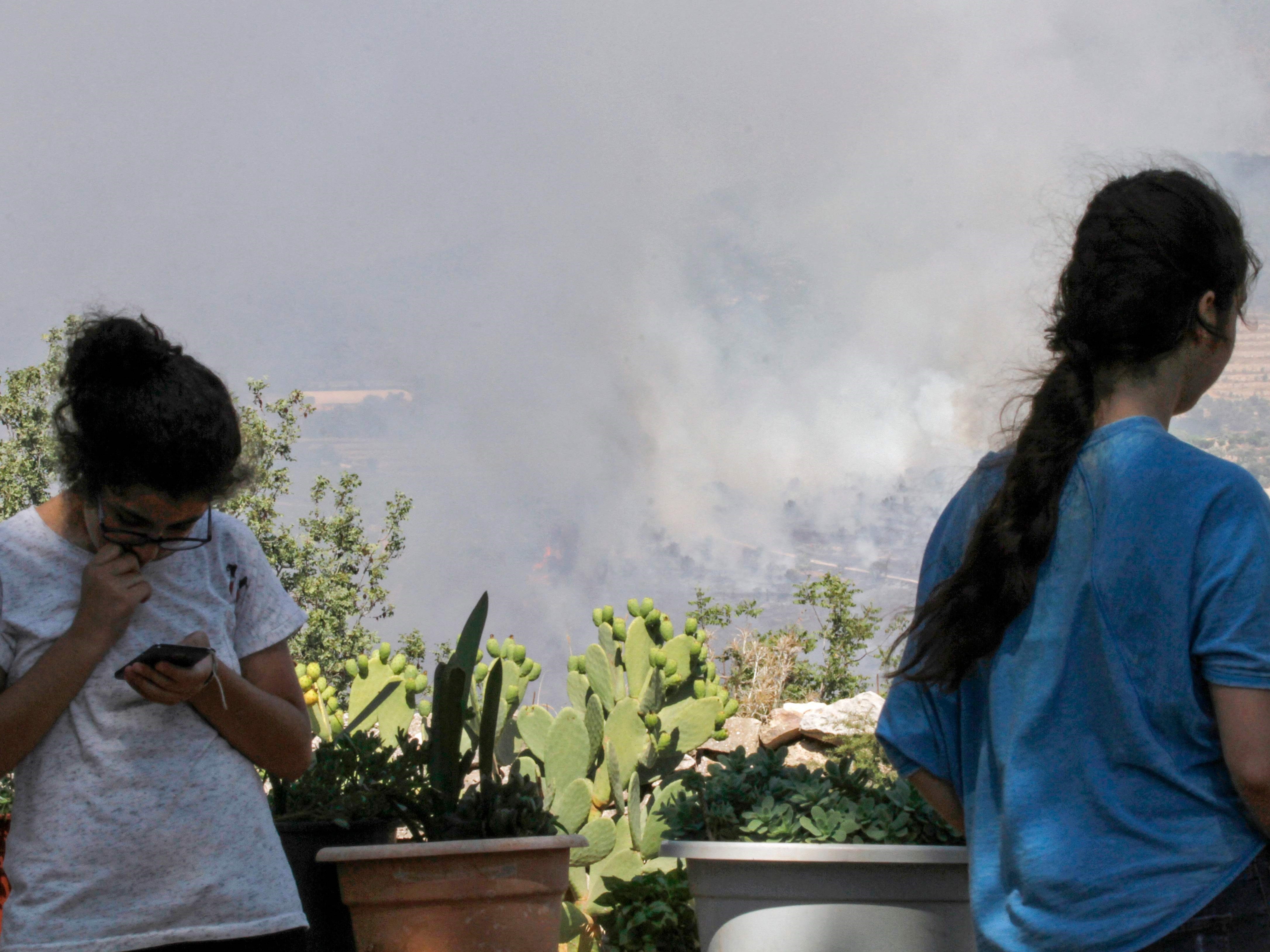 Gadis-gadis Libanon di kota Ibl Al-Saqi, Lebanon selatan, saat asap mengepul akibat serangan oleh pasukan Israel, Rabu (4/8).