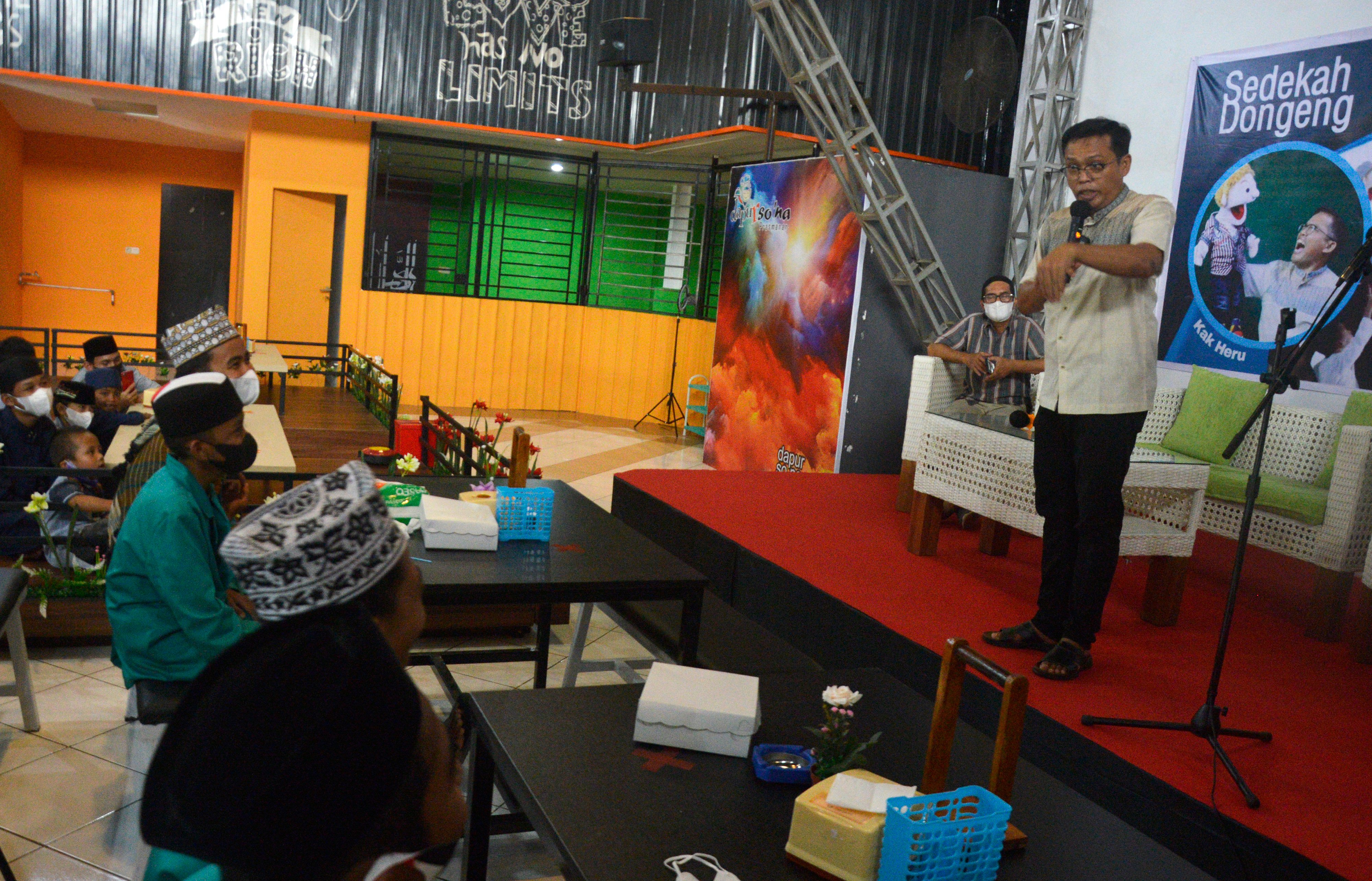 Pendongeng Kak Heru (kanan) menghibur anak yatim piatu saat sedekah dongeng di Kabupaten Gowa, Sulawesi Selatan, Jumat (4/6/2021)