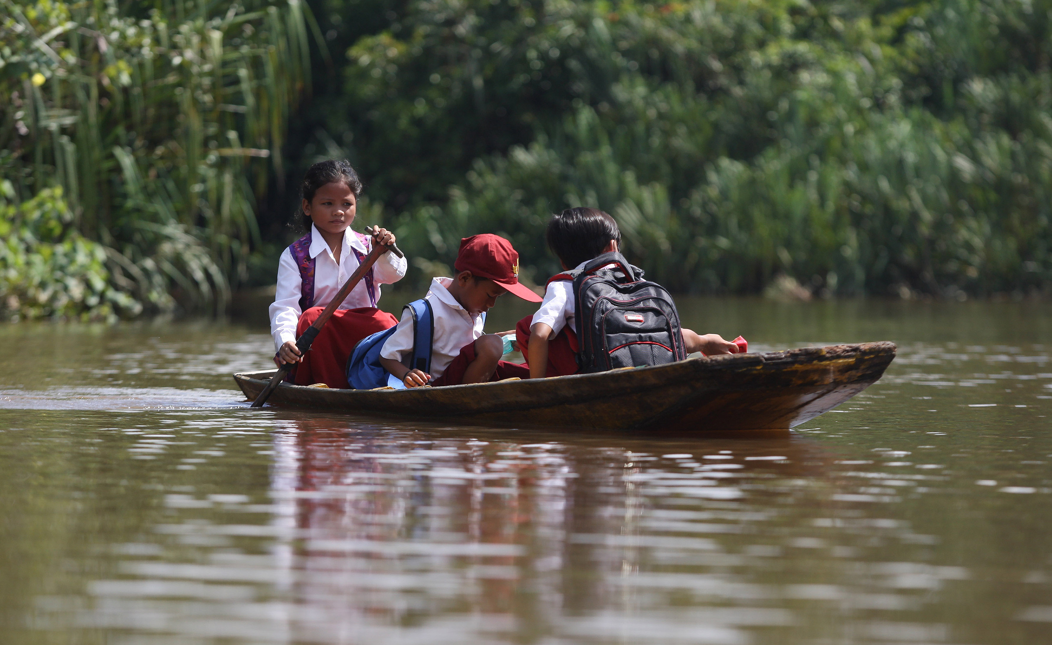 Pelajar menaiki sampan saat berangkat sekolah menyeberangi Sungai Sambas Besar di Desa Semanga, Kecamatan Sajingan Kecil, Kab Sambas, Kalbar