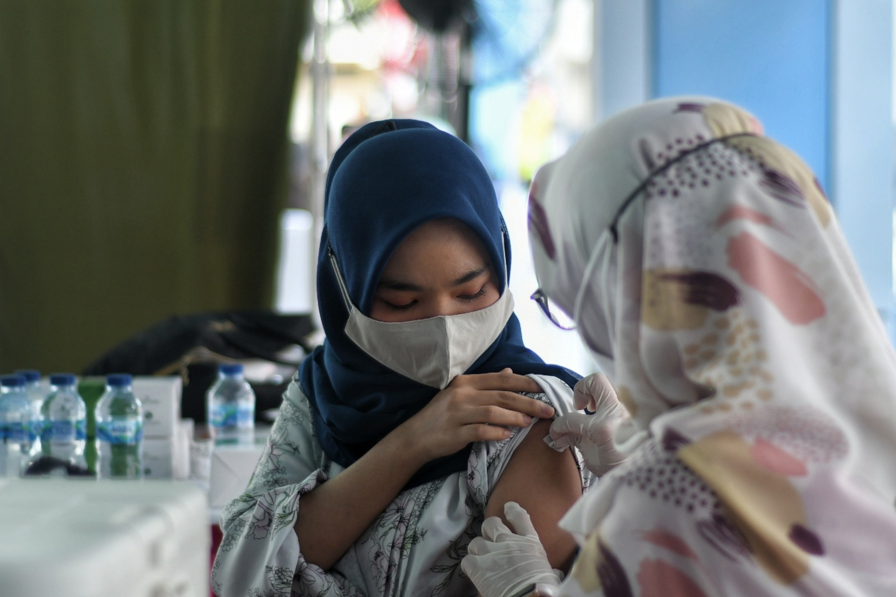  Tenaga kesehatan menyuntikan vaksin Covid-19 pada warga di Stasiun Juanda, Jakarta, Jumat (20/8/2021). 