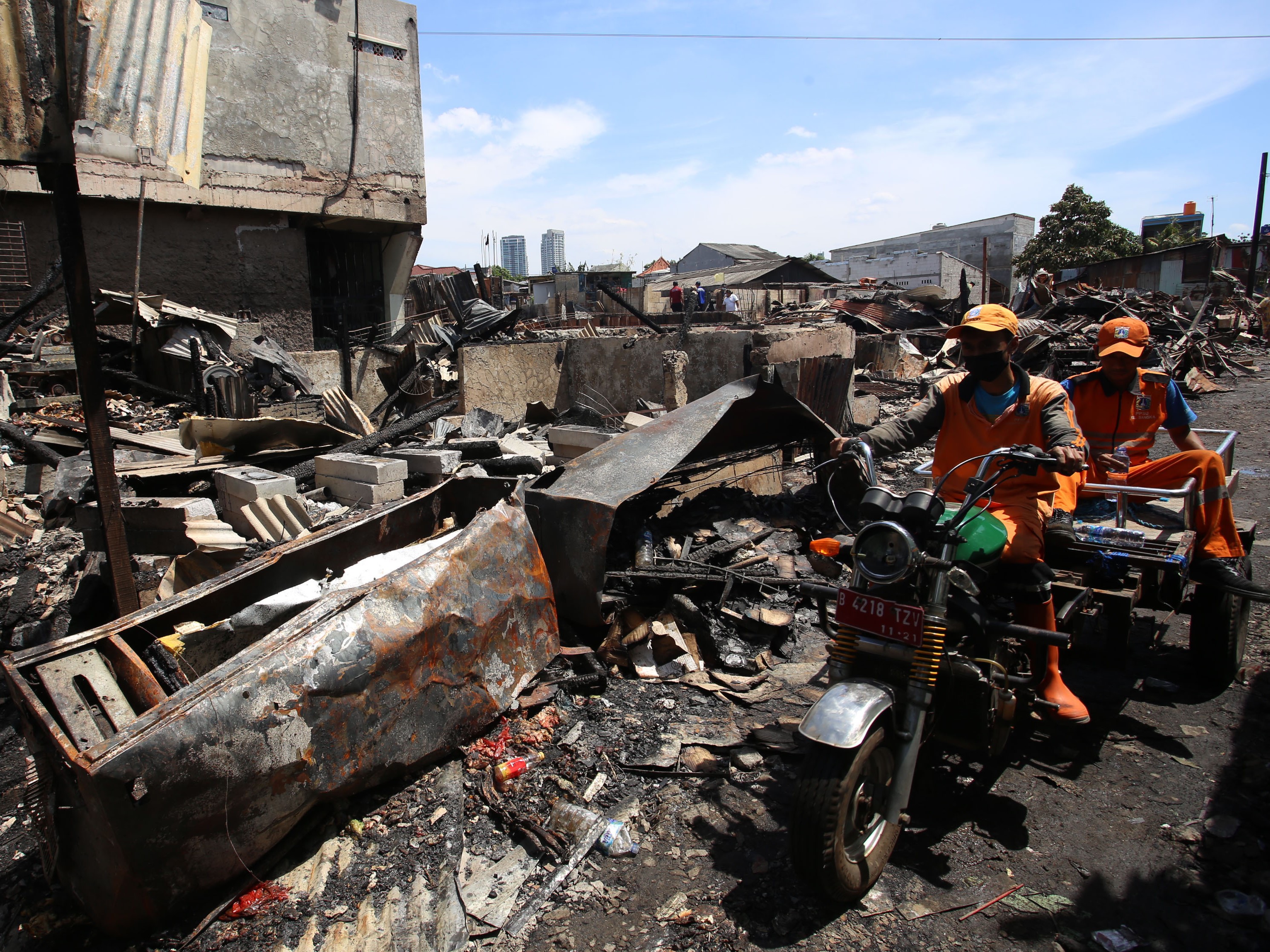 Petugas PPSU melintasi lokasi kebakaran yang menelan korban jiwa tiga orang akibat terjebak kebakaran, Kemang, Jakarta, Minggu (15/8).