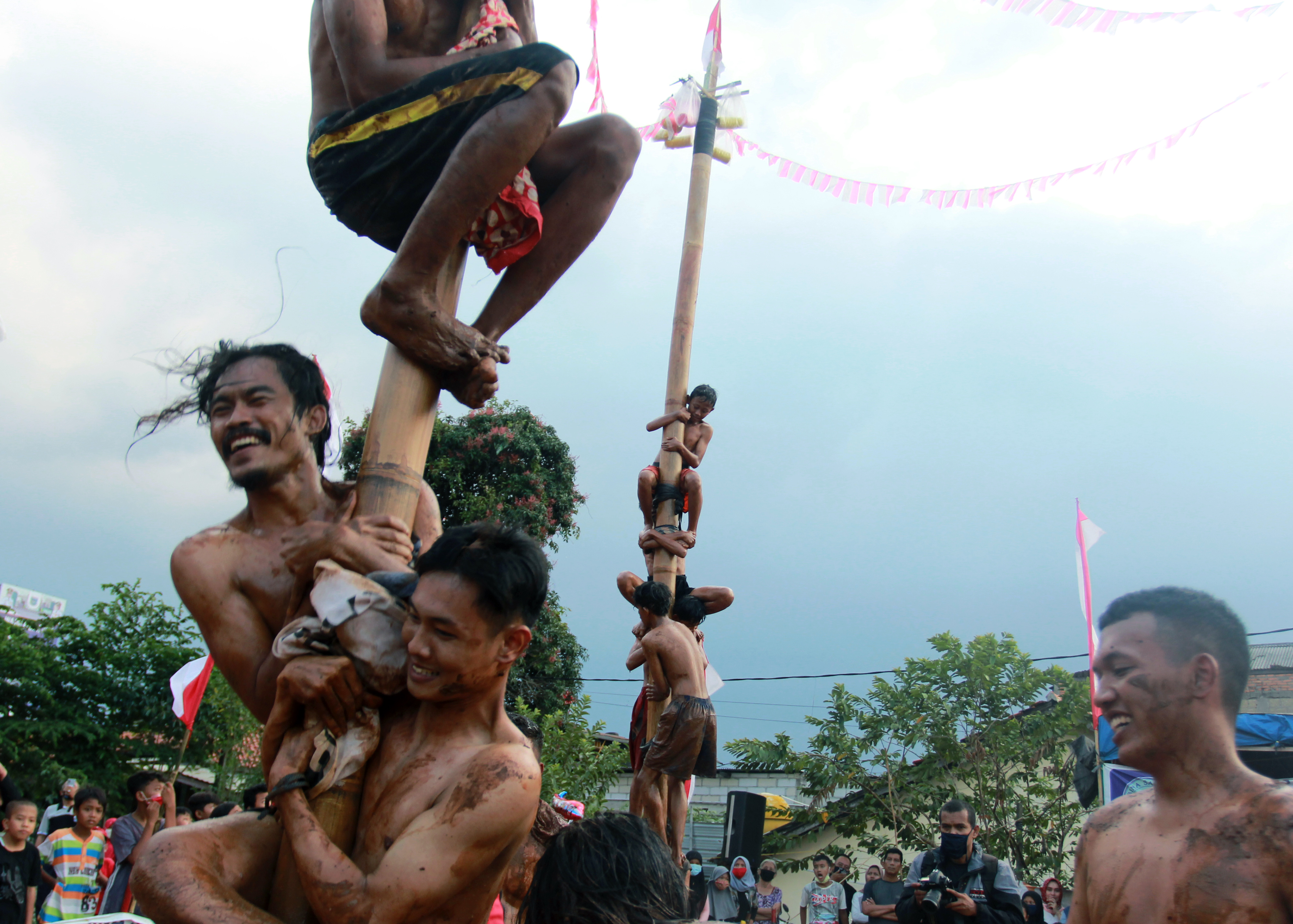 Ilustrasi-- Sejumlah peserta bahu membahu mengikuti lomba panjat pinang di Pondok Cabe, Tangerang Selatan, Banten, 17 Agustus 2020.