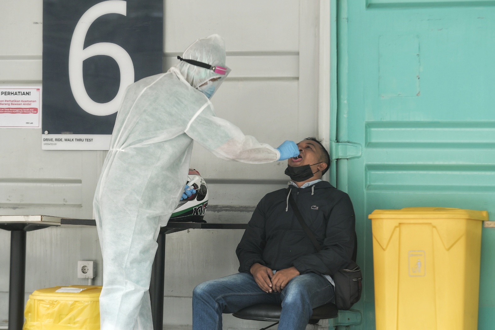 Petugas medis melakukan tes PCR kepada warga di wilayah Jakarta.