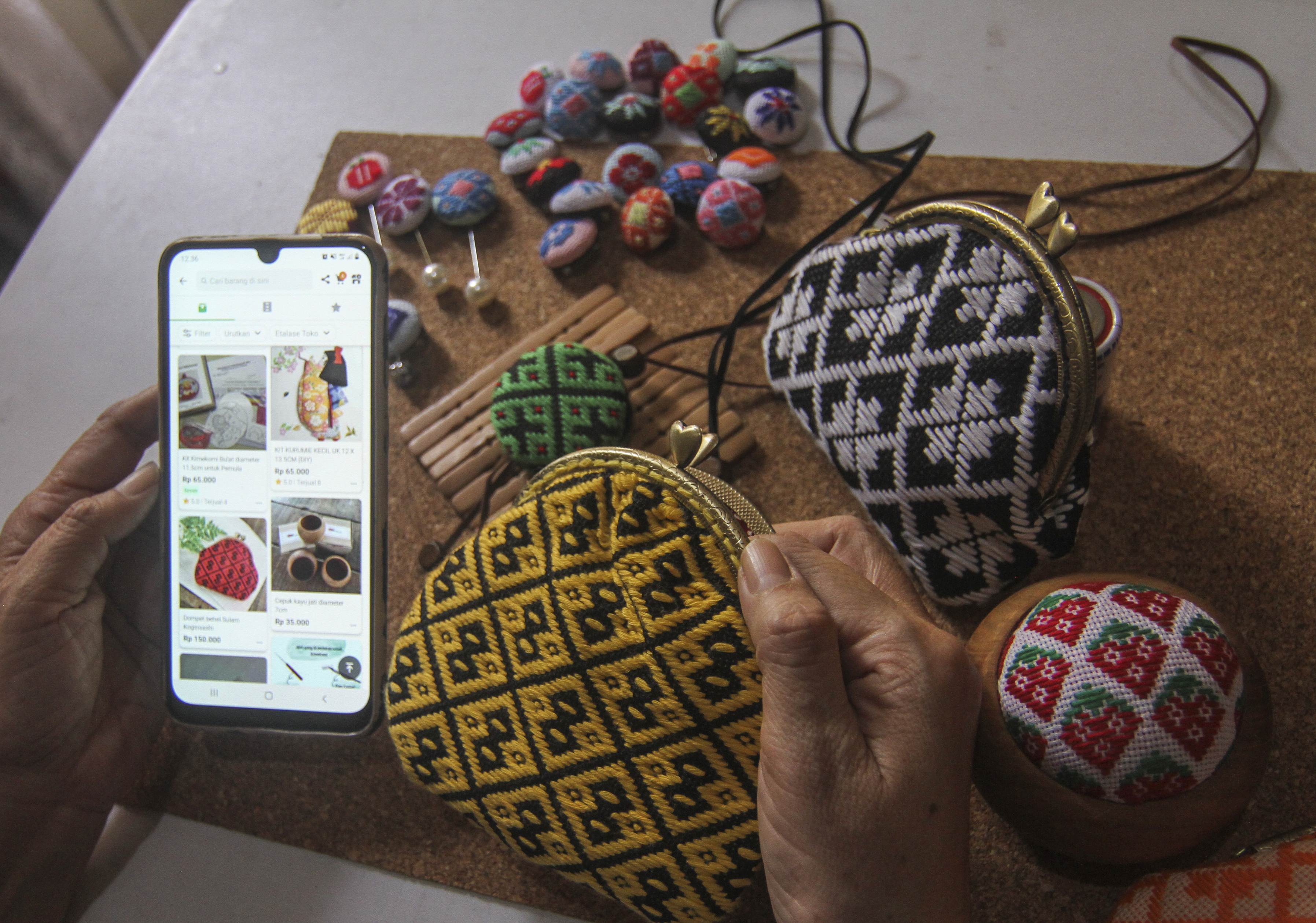 Perajin melihat stok kerajinan aksesori koginsashi miliknya pada aplikasi jual beli di Asriku Kreasi, Depok, Jawa Barat, Minggu (1/8/2021)