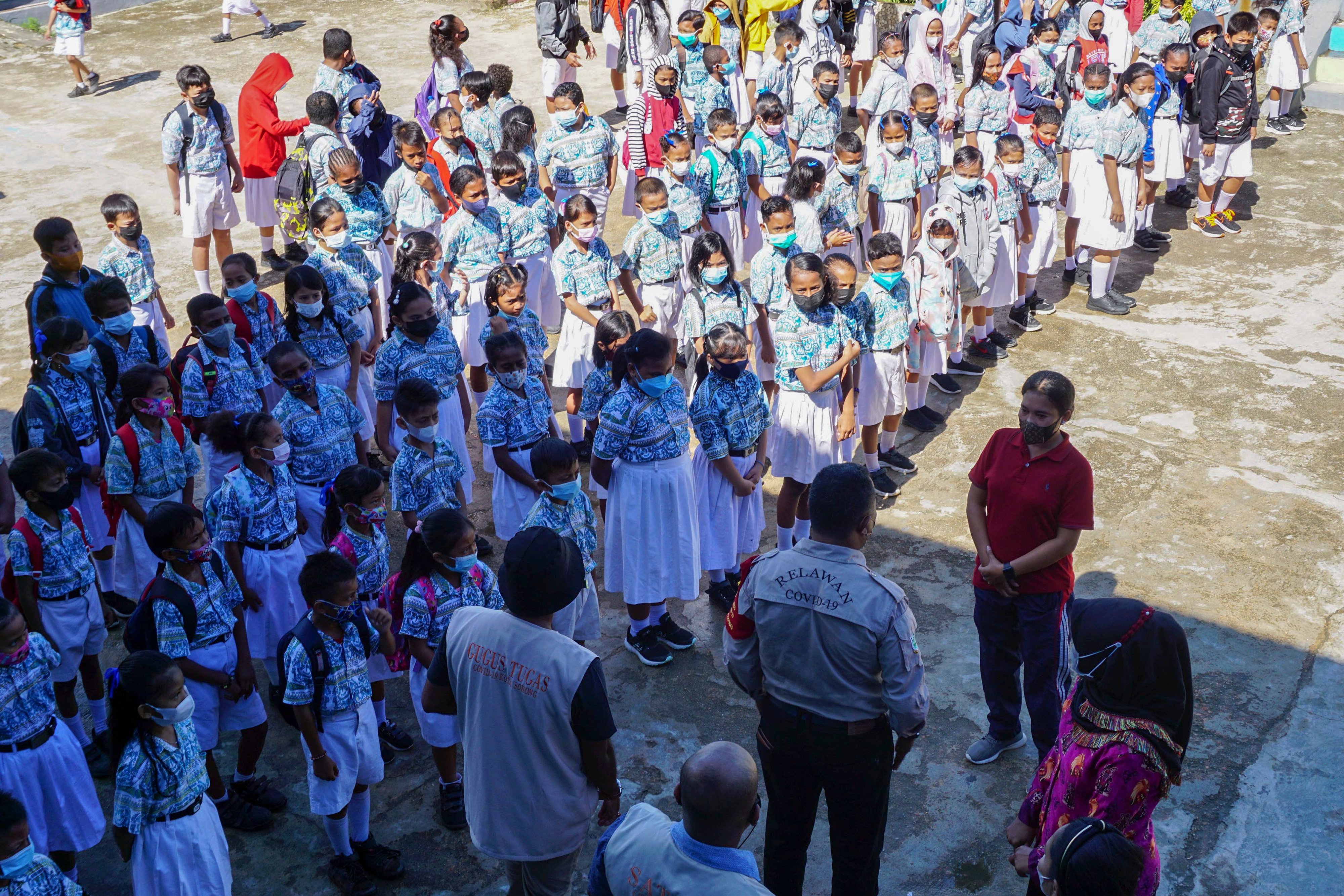 Satgas Covid-19 (kiri) berbincang dengan guru sebelum pembelajaran tatap muka di SD Negeri 2 Kota Sorong, Papua Barat, Kamis (26/8/2021)