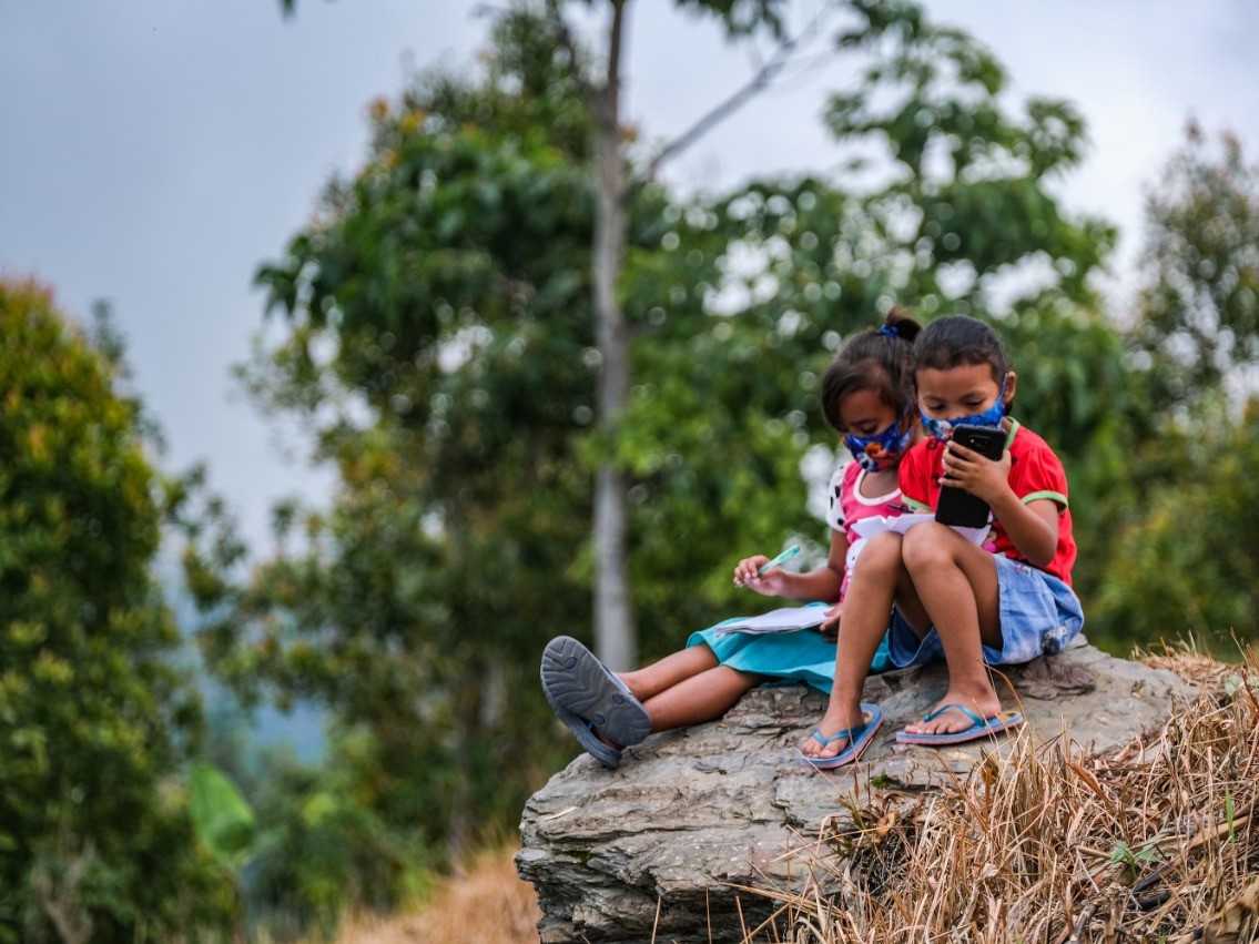 Kristin Frederika (kiri) dan Mumut Kartika siswi kelas 1 SD Inpres Matantimali belajar jarak jauh di bukit. MI/BRIYANBODO HENDRO