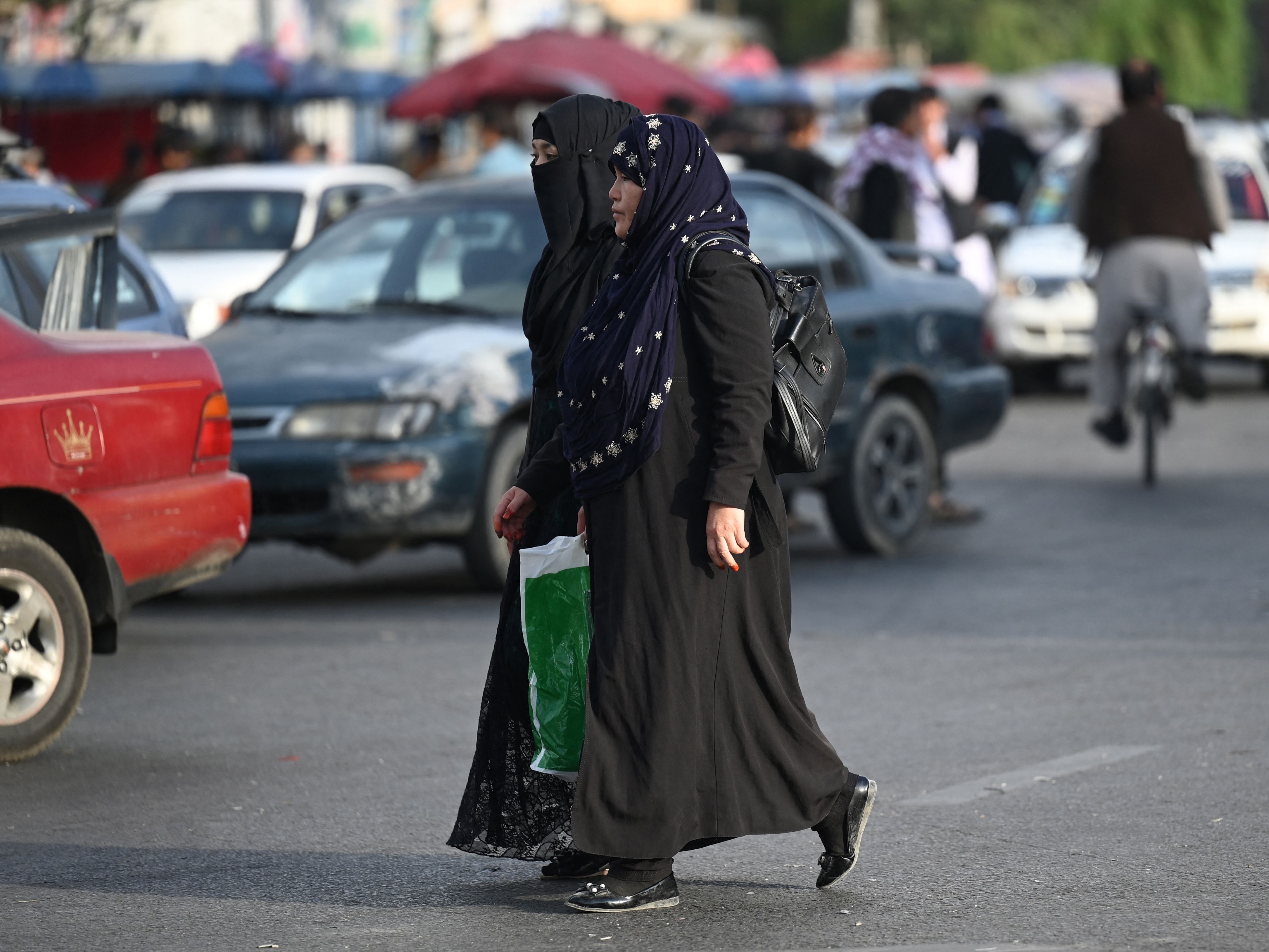 Perempuan Afganistan menyeberang jalan di Kabul pada Selasa (31/8).