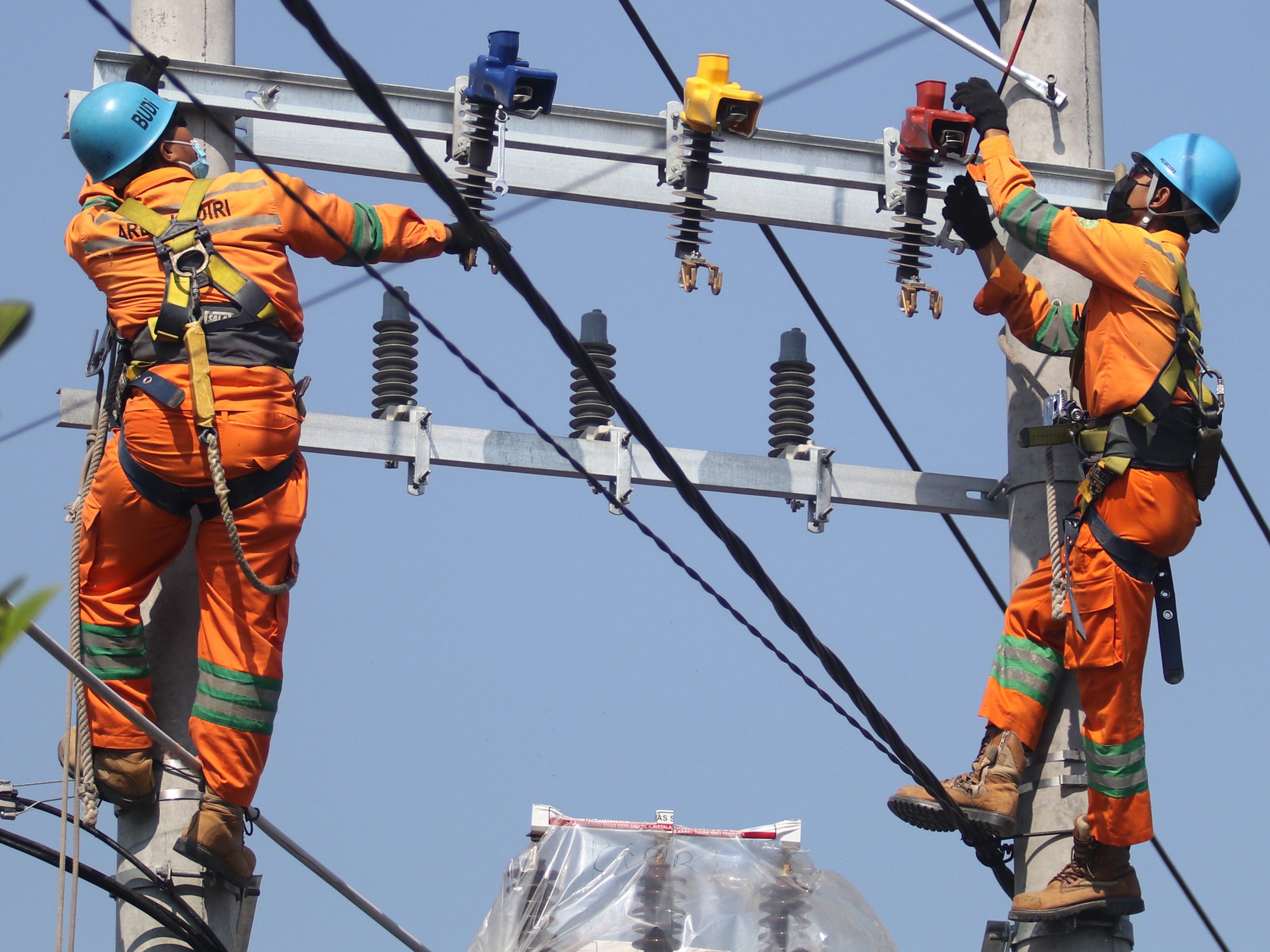 Pekerja PLN melakukan perawatan pada jaringan listrik dalam keadaan masih bertegangan di Desa Ngasem, Kediri, Jatim.