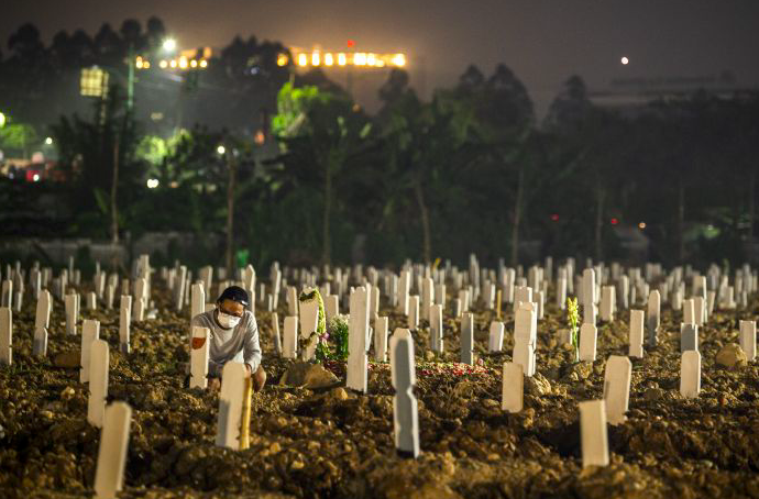 Warga berdoa di dekat pusara keluarganya di area pemakaman khusus COVID-19 di TPU Rorotan, Cilincing, Jakarta Utara.