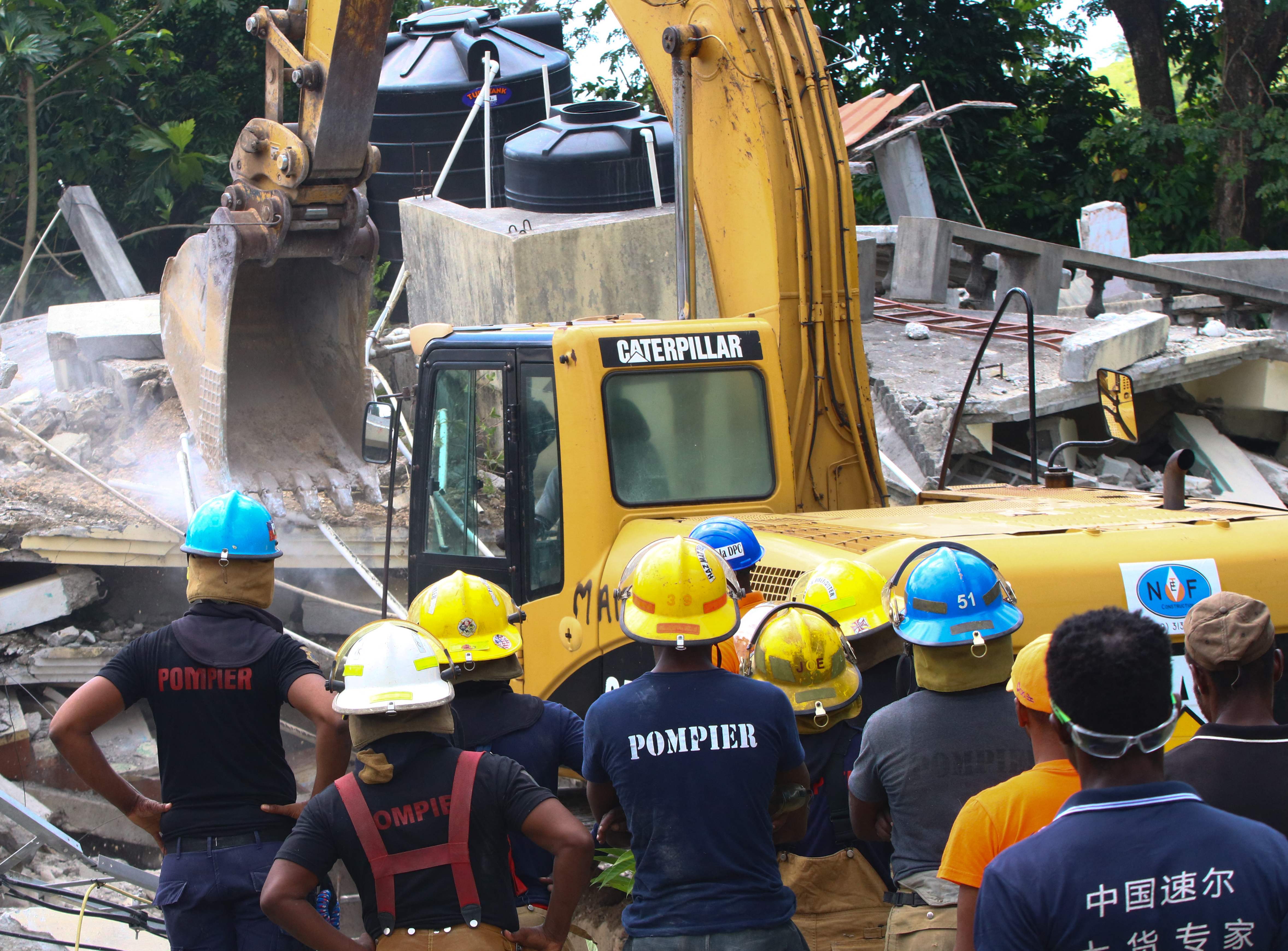 Tim penyelamat sedang melakukan aksi menemukan korban-korban reruntuhan akibat gempa bumi di Haiti