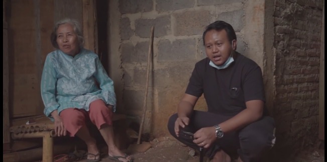 Seorang Youtuber, R Gunawan (kanan) berbincang dengan seorang warga.