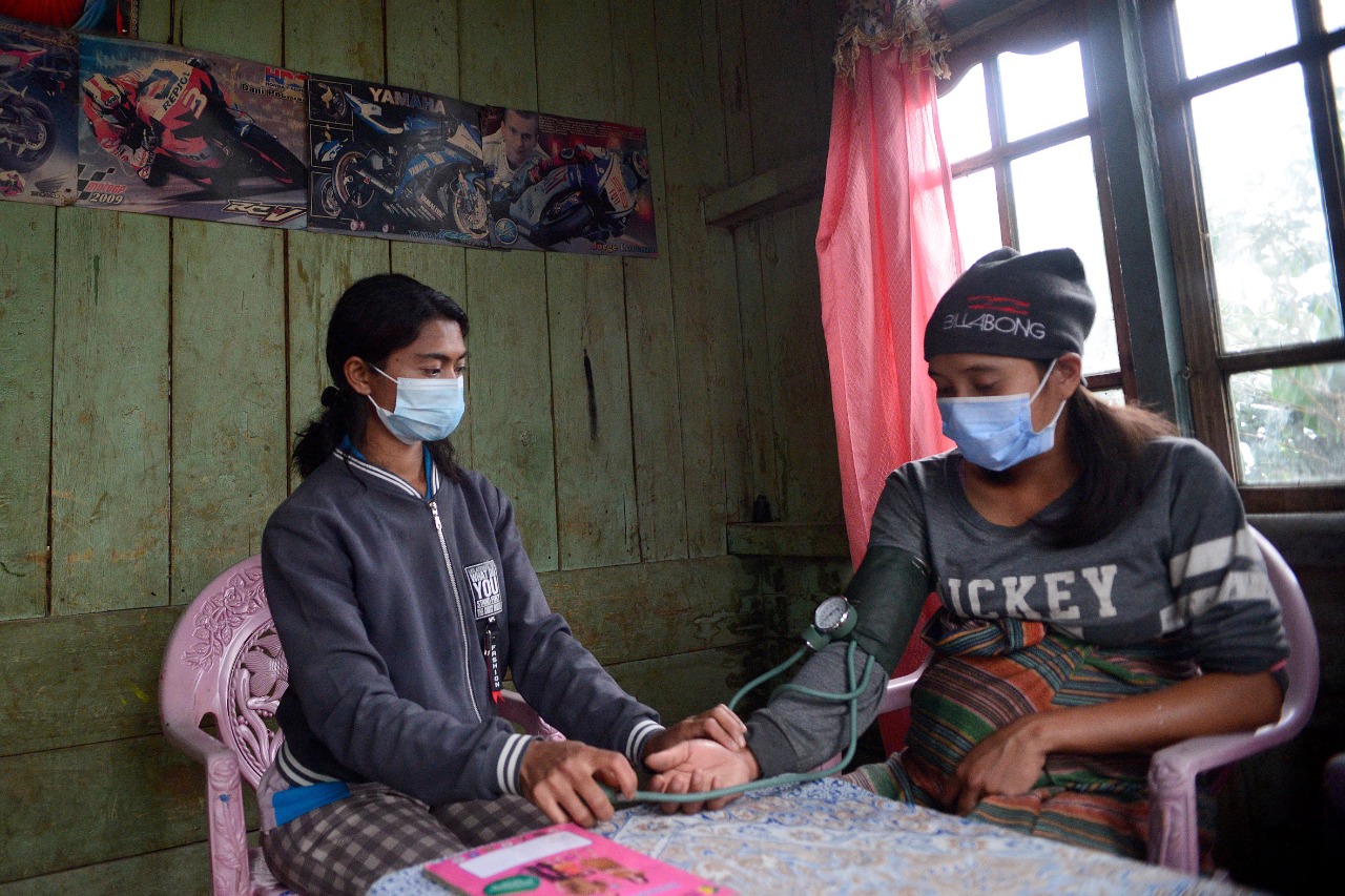 Bidan Ellen (kiri) melakukan kunjungan langsung unutk memeriksa kondisi kesehatan pasien ibu hamil di Desa Colol, Manggarai Timur, NTT.