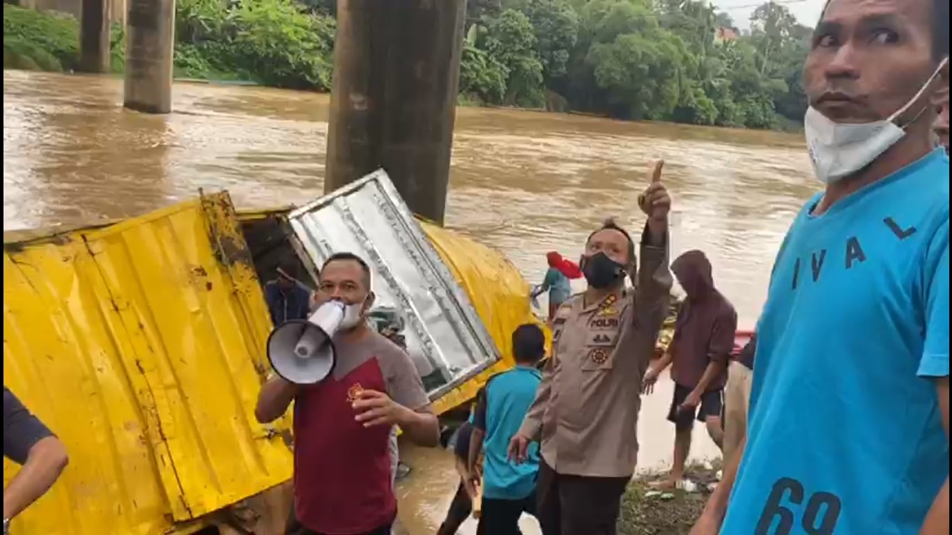 Petuga kepolisian dibantu warga sekitar mengevakuasi truk bermuatan sembako yang terjun ke sungai di KM 53, Kabupaten Bungo, Jambi, Sabtu (2