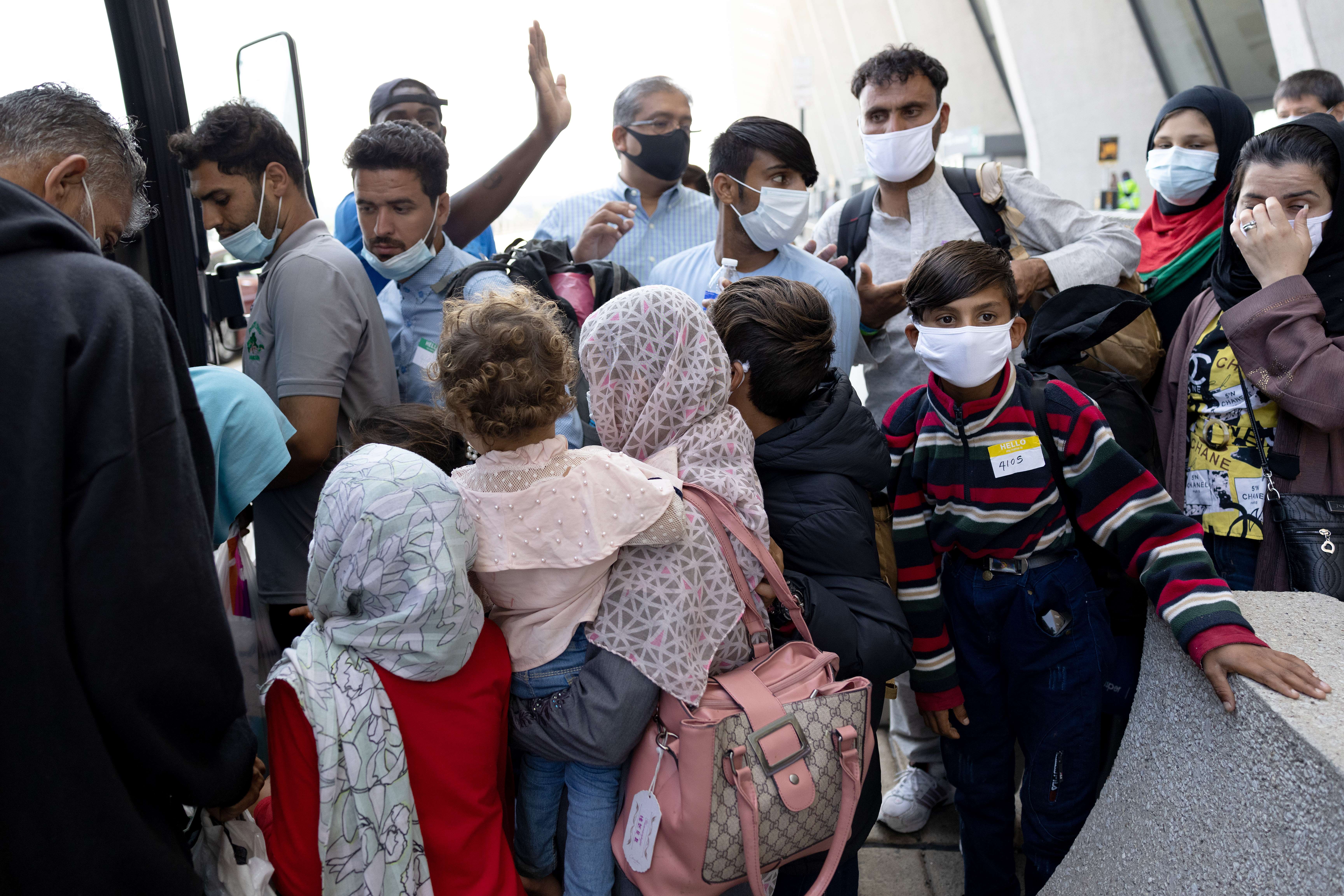 Pengungsi Aghanistan menunggu bus yang akan mengangkut mereka ke tempat penampungan di Dulles, Virginia, AS.
