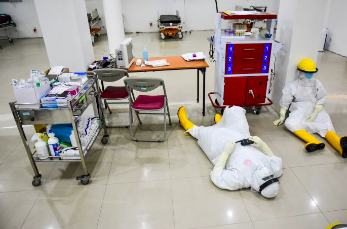 Sejumlah perawat beristirahat dengan mengenakan alat pelindung diri di IGD khusus penanganan COVID-19 di RSUD Arifin Achmad, Riau. 