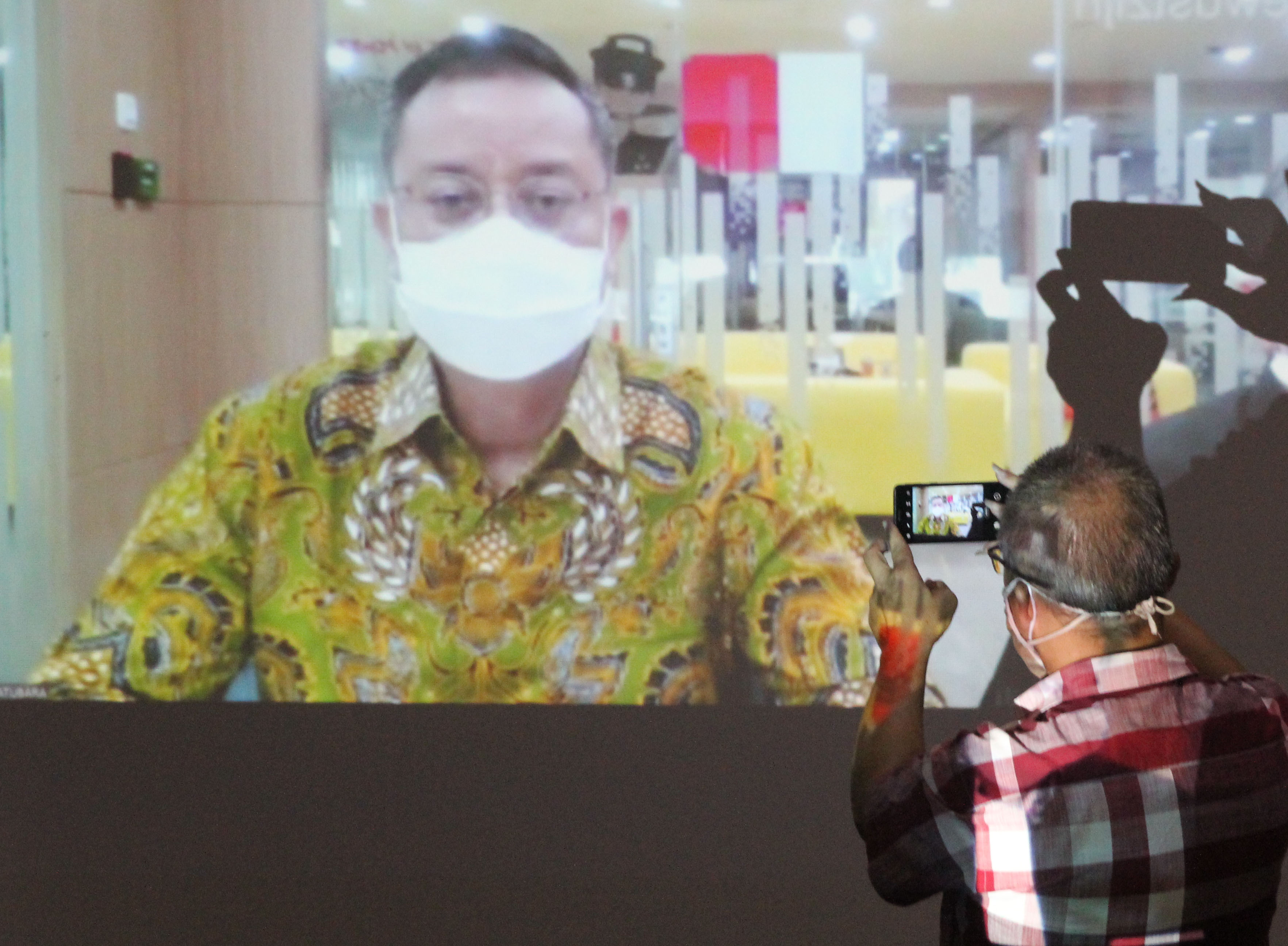 Seorang wartawan mengabadikan sidang virtual terdakwa eks Menteri Sosial Juliari Batubara di Gedung Merah Putih KPK, Jakarta.