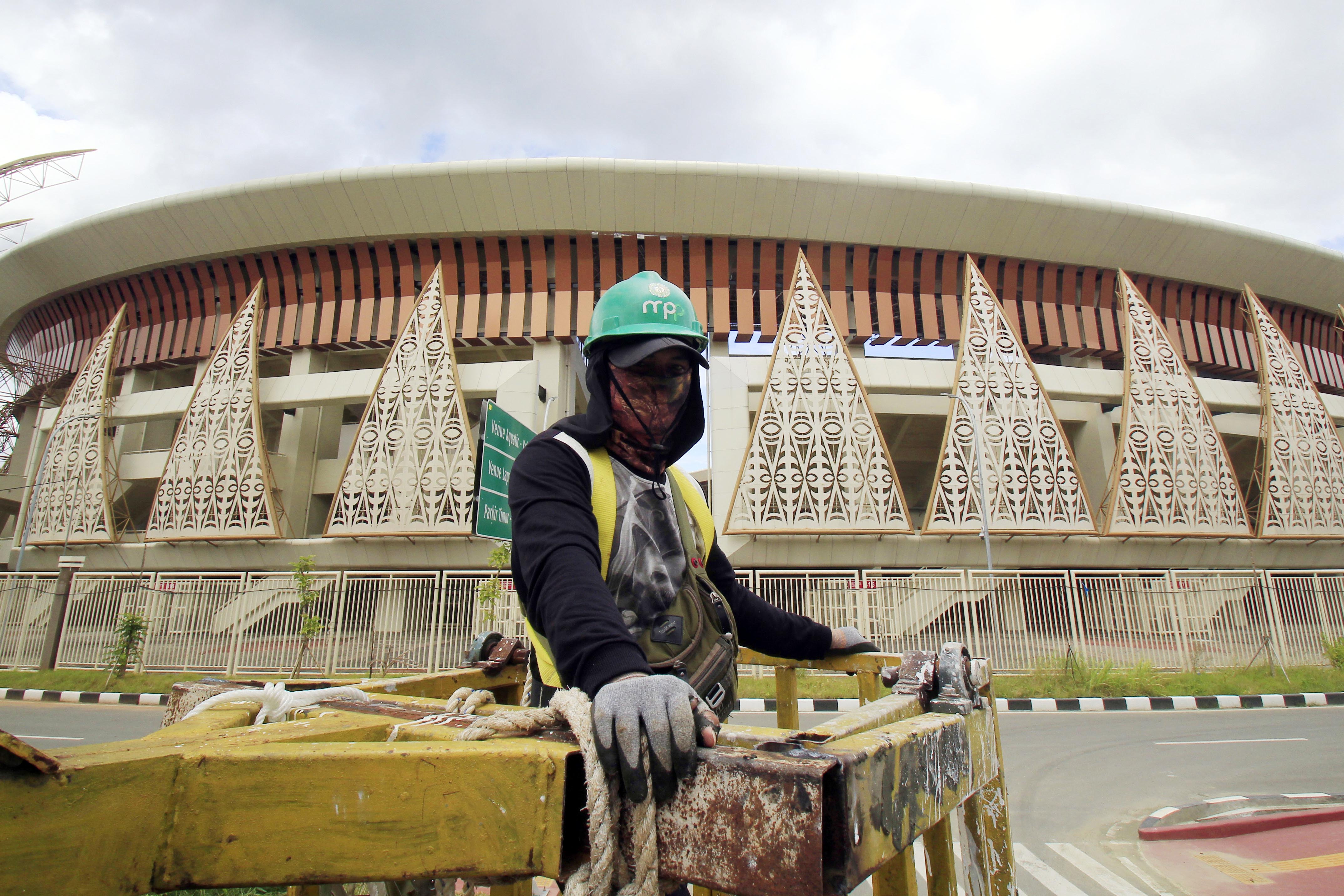 Pekerja bersiap memasang fasilitas penerangan di kawasan Venue PON XX Papua, Kampung Harapan, Jayapura, Papua.