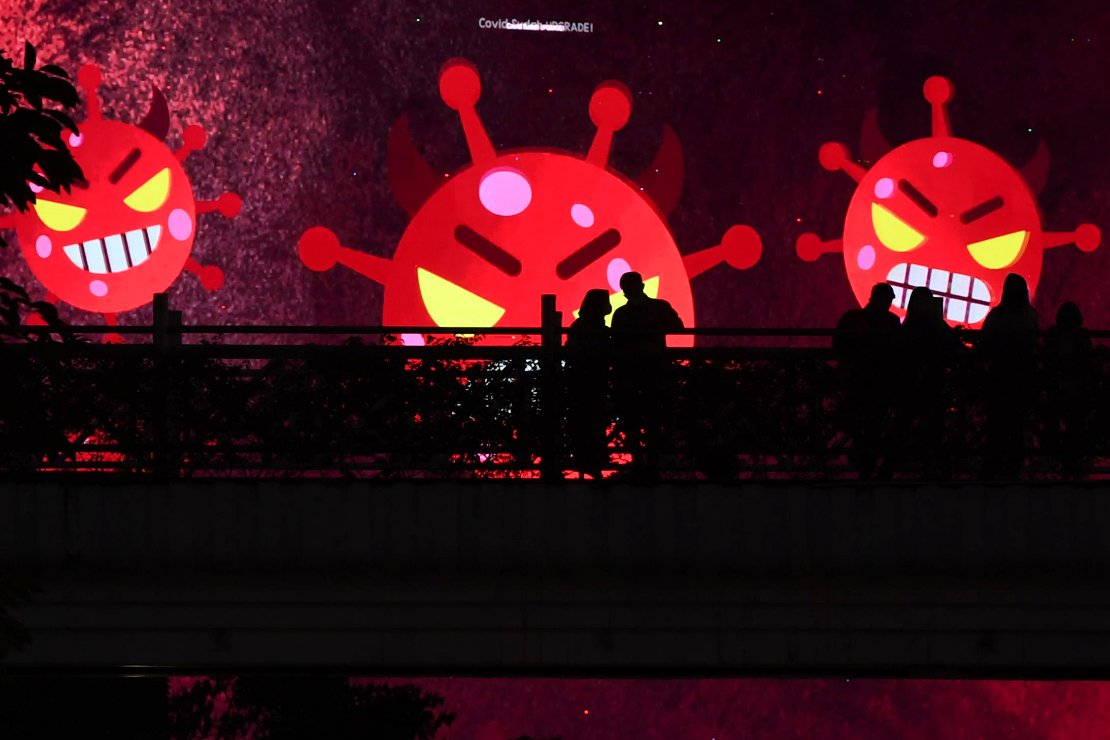 Sejumlah warga berdiri di area Jembatan Penyeberangan Orang (JPO) kawasan Sudirman, Jakarta, Senin (23/8). 