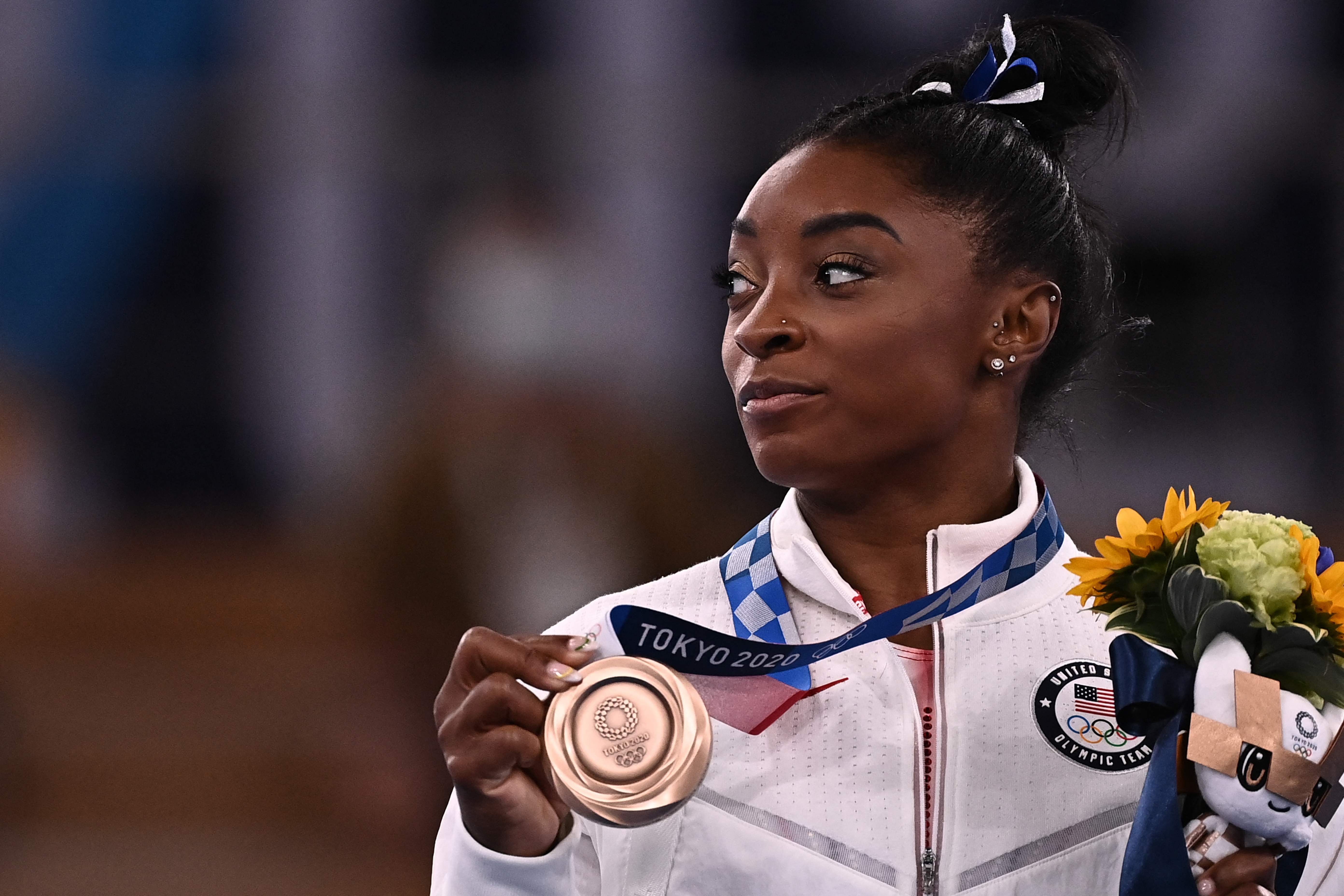 Pesenam asal AS Simone Biles berpose dengan medali perunggu di Olimpiade Tokyo 2020.