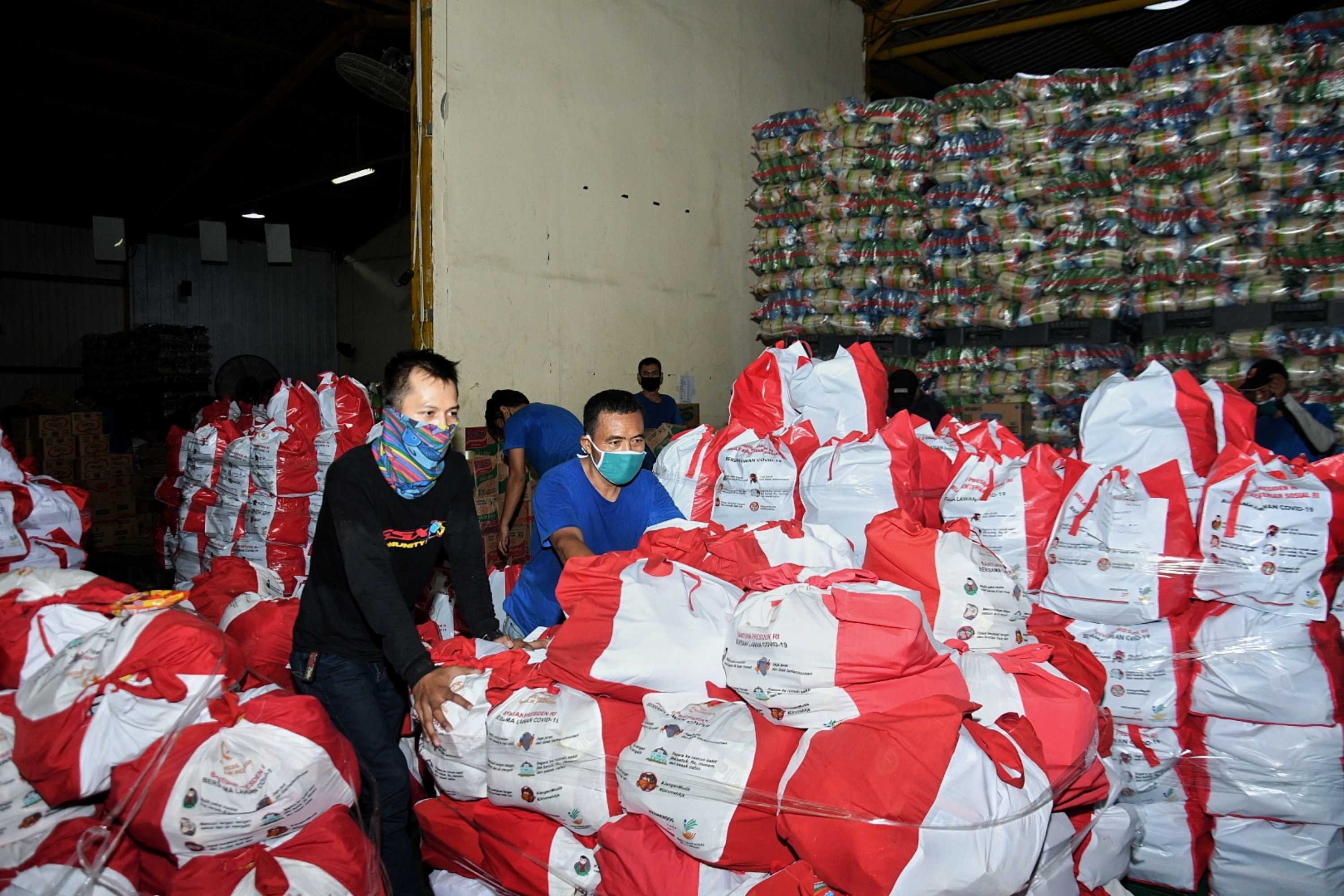 Ilustrasi warga mendorong paket bansos dari gudang di tengah pandemi covid-19. 