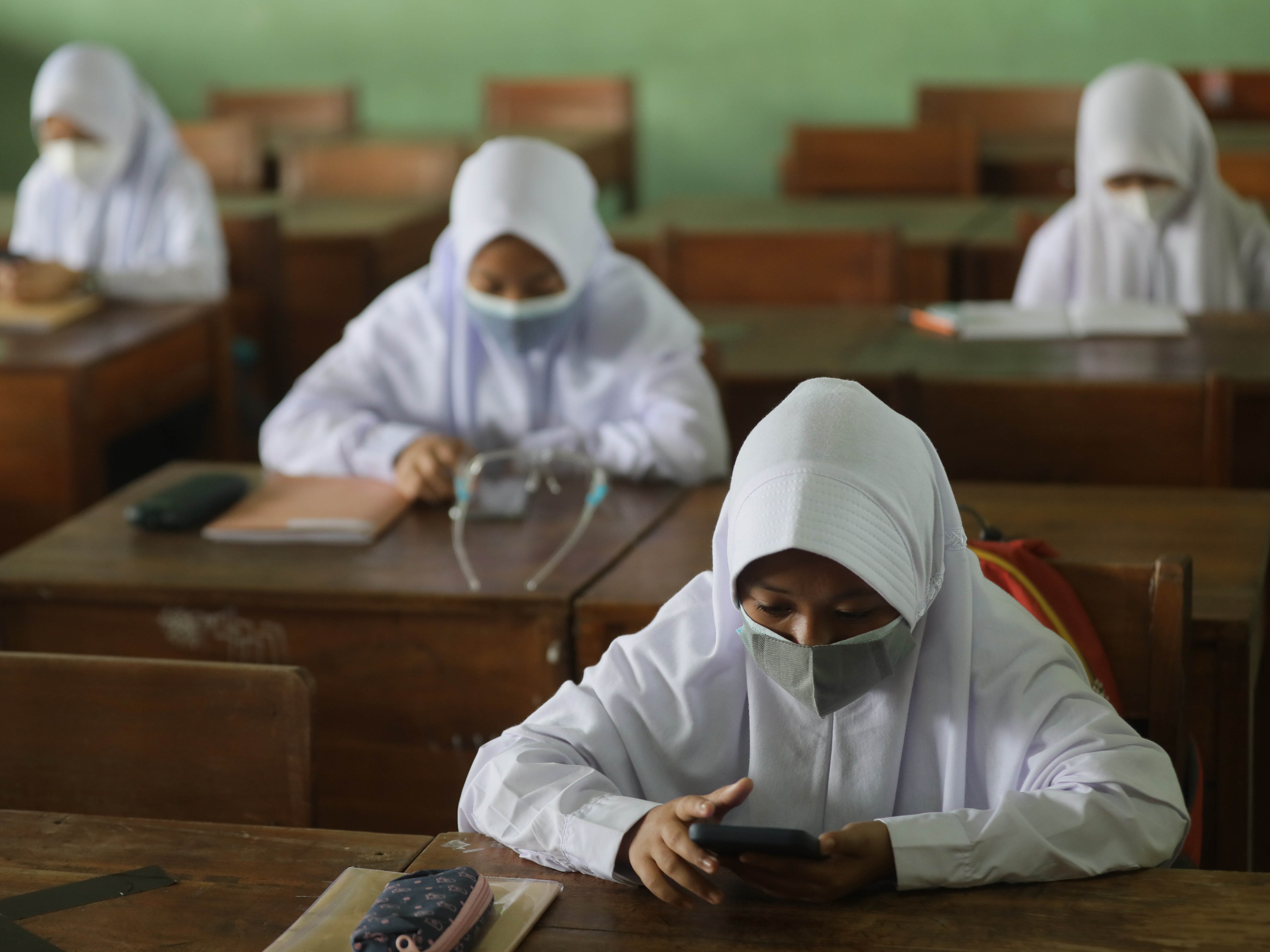 Siswa kelas 7 menggunakan buku pelajaran sekolah elektronik dari telepon seluler di SMP 245, Petukangan, Jakarta, Senin (30/8).