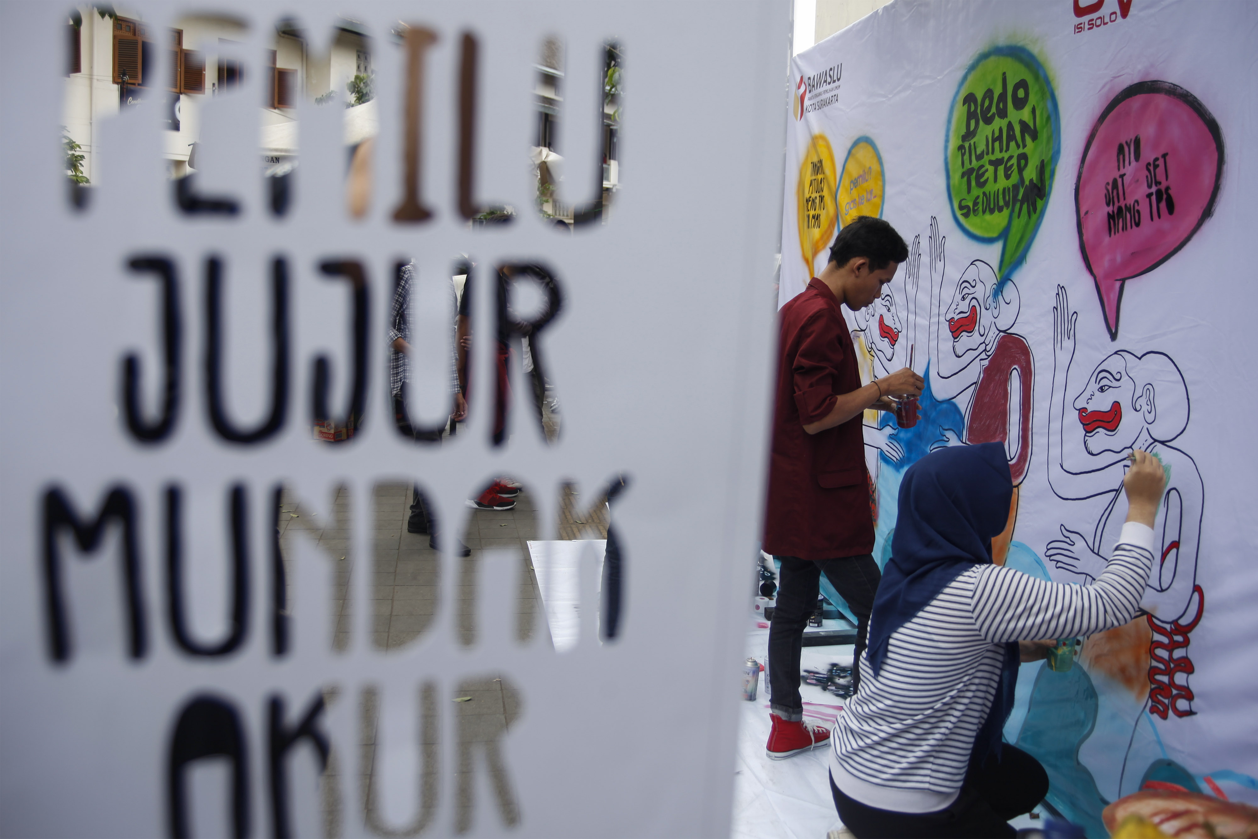 Mahasiswa ISI Surakarta membuat mural dengan tema pemilu di Pasar Gede, Solo.
