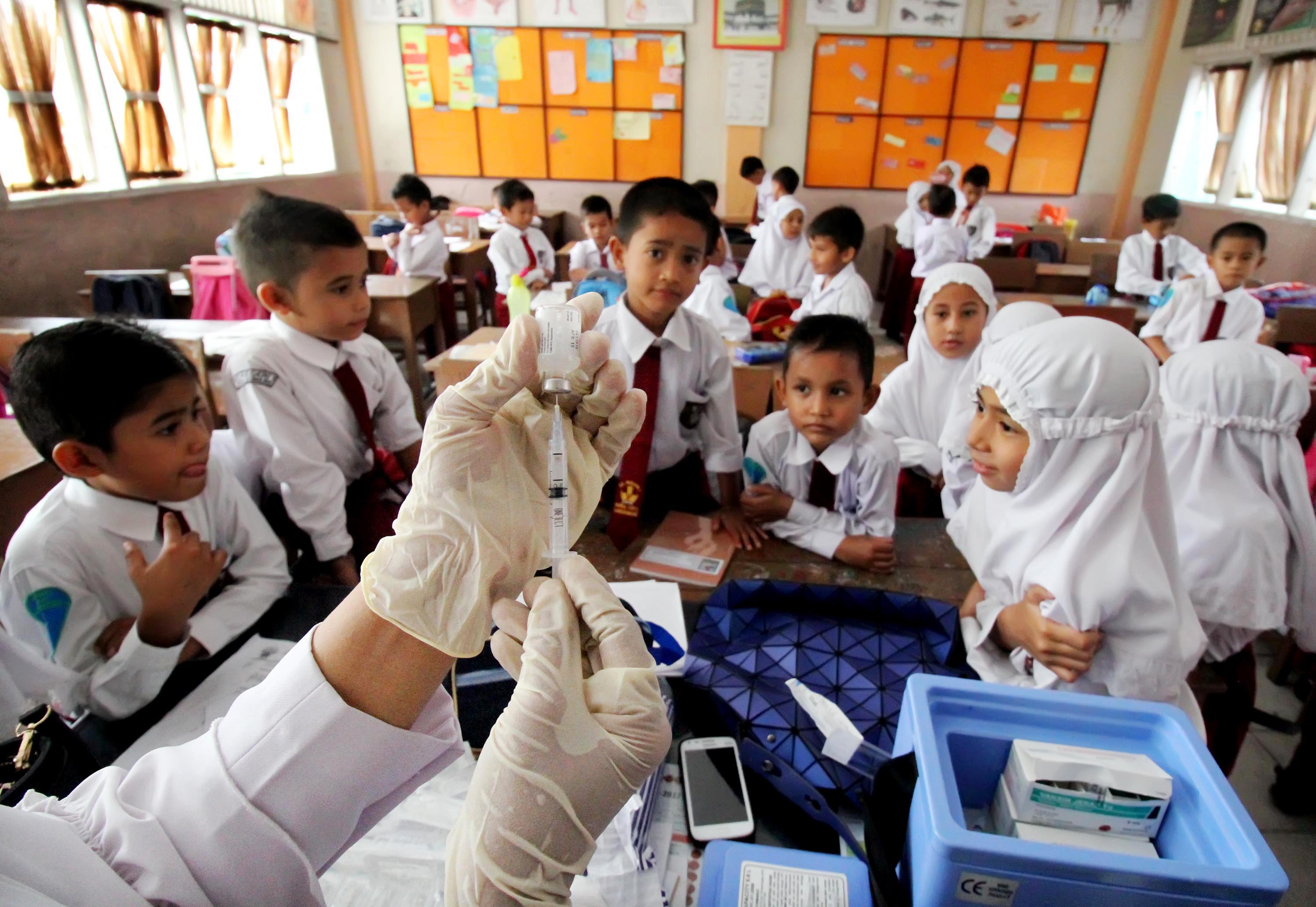 Siswa yang akan menjalani imunisasi Tetanus melihat jarum suntik di SDN-1 Lhokseumawe, Provinsi Aceh.