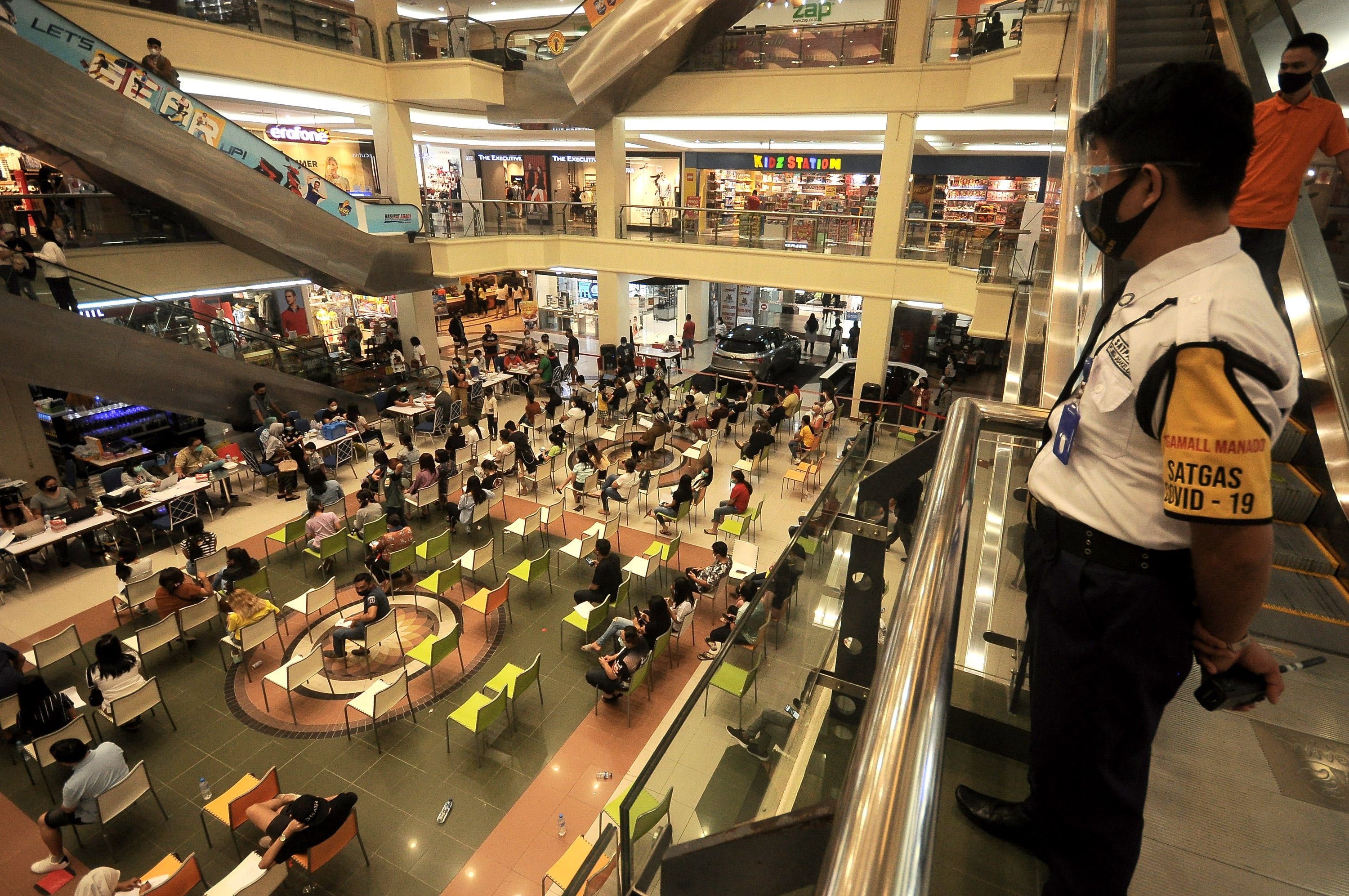 Petugas keamanan mengawasi program vaksinasi umum di salah satu pusat perbelanjaan di Manado, Sulawesi Utara.