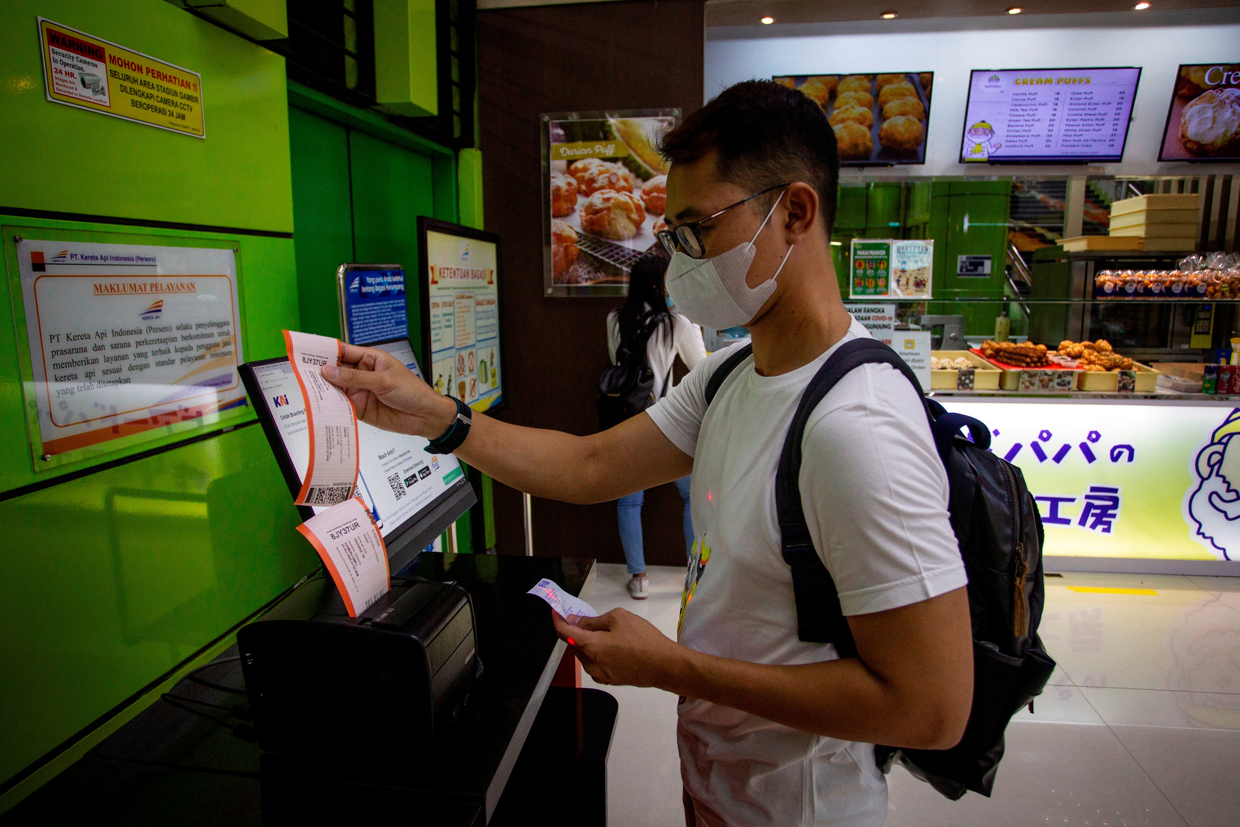 Calon penumpang mencetak tiket di Stasiun Gambir, Jakarta.