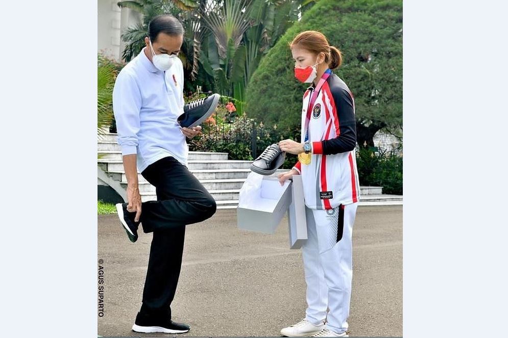 Presiden Joko Widodo (kiri) mencoba sepatu merek Fine Counsel milik Greysia Polii.