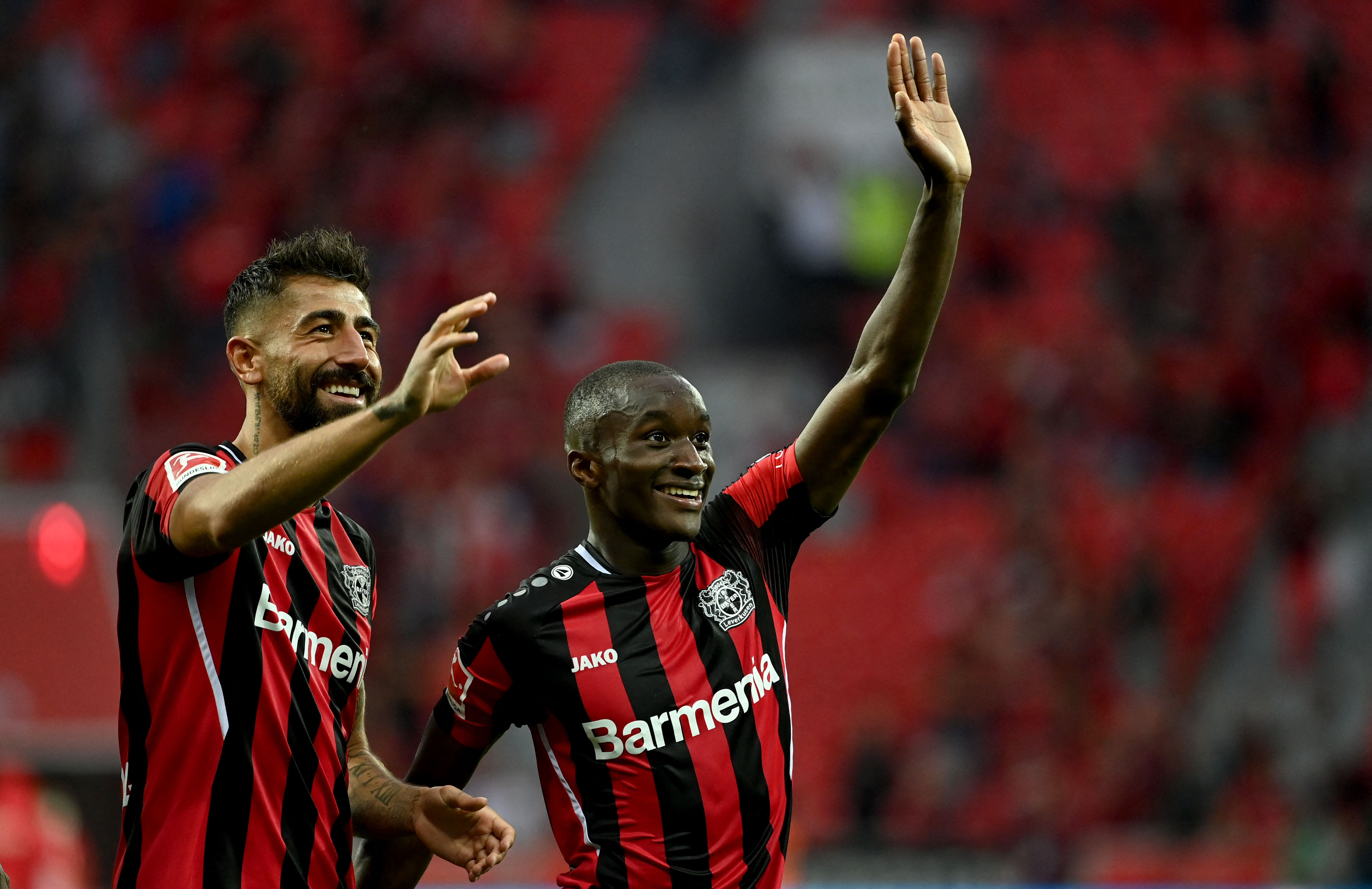 Dua pemain Bayer Leverkusen menyapa para pendukung usai mengalahkan Borussia Moenchengaldbach di laga Bundesliga.