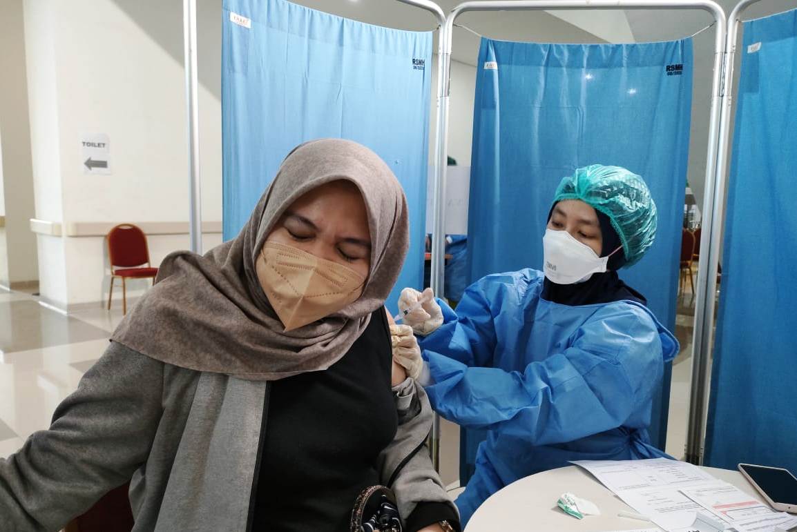 Seorang ibu hamil sedang disuntik vaksin covid.