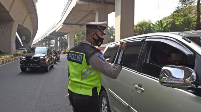 Polantas memberikan sosialisasi kepada pengendara soal pemberlakukan ganjil-genap