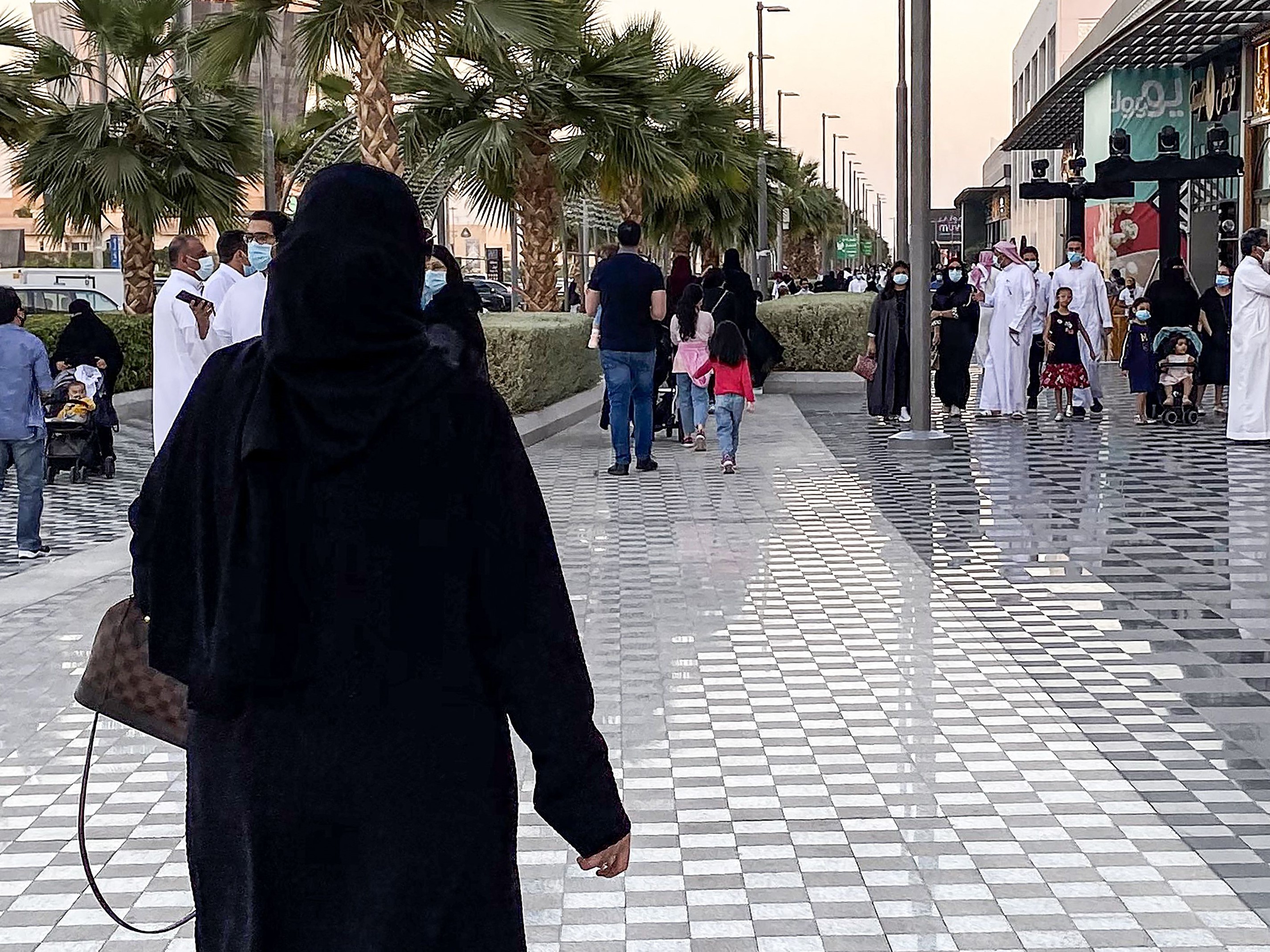 Seorang wanita berjalan di sepanjang kawasan pedestrian di luar pusat perbelanjaan di ibu kota Arab Saudi, Riyadh, pada 31 Oktober 2020.