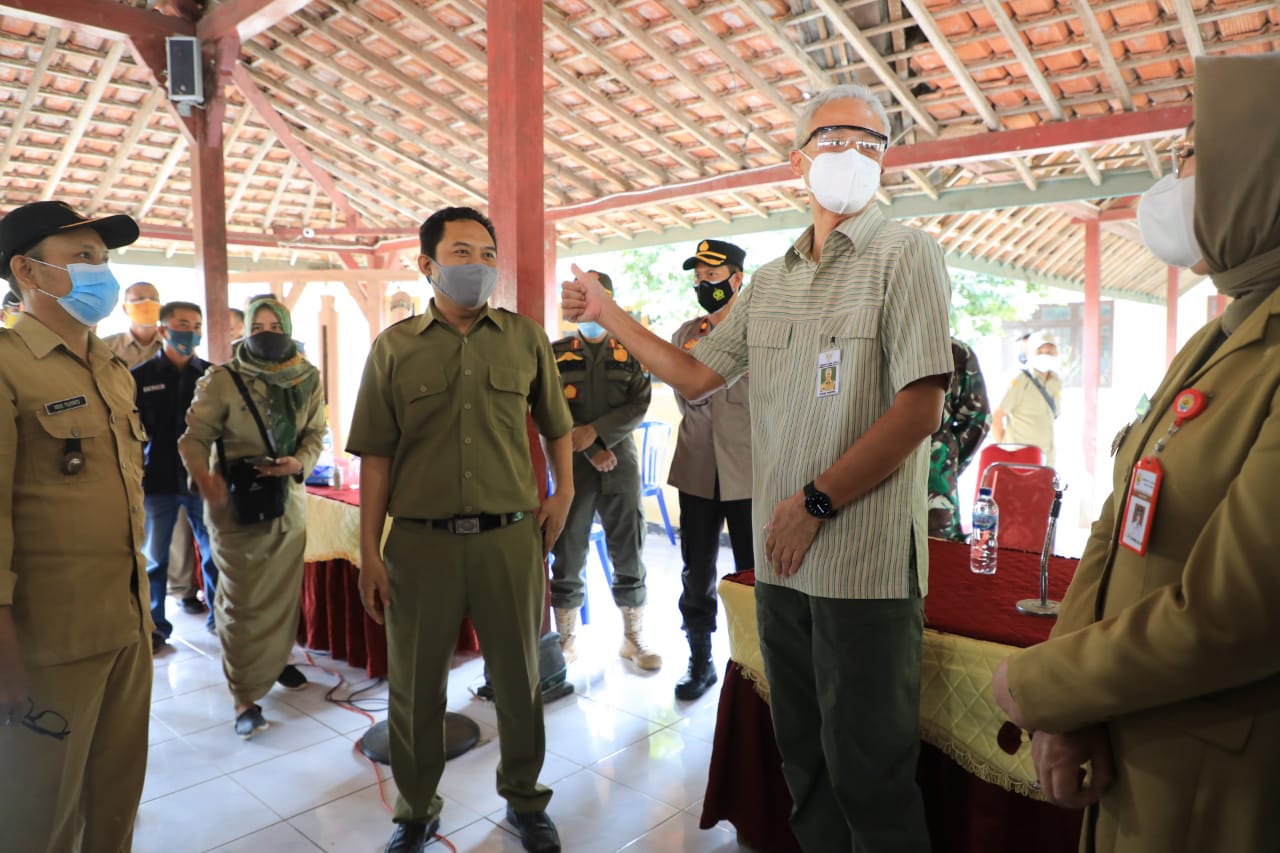 Gubernur Jawa Tengah Ganjar Pranowo (kedua dari kanan) meninjau pembagian BST di Desa Panunggalan Kecamatan Pulokulon Grobogan, Selasa (3/8)