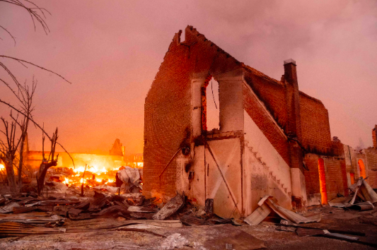 Bangunan terbakar saat api Dixie merobek pusat kota Greenville, California pada 4 Agustus 2021.