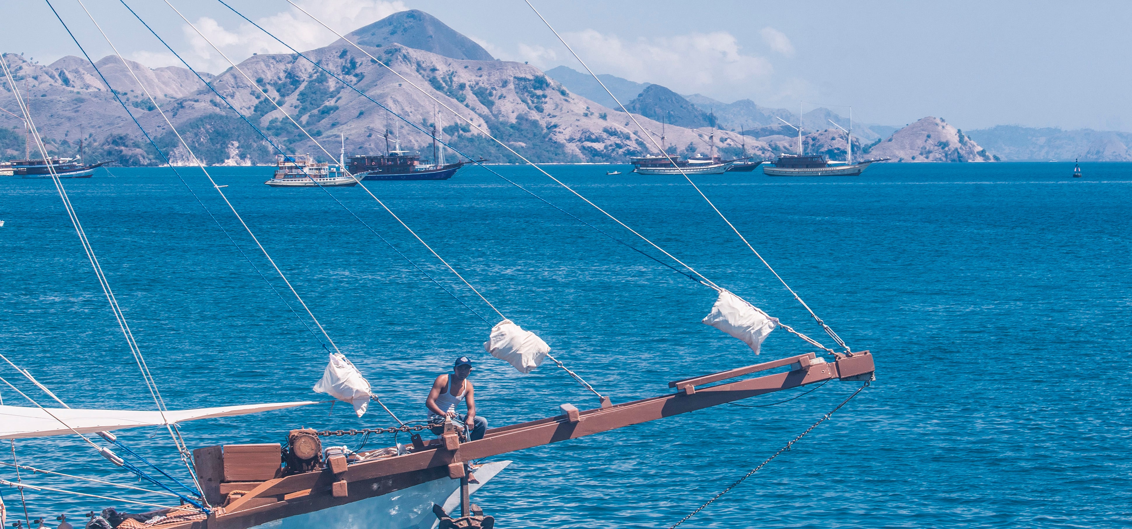 Kapal wisata Pinisi melintas di dekat Dermaga Labuan Bajo, Nusa Tenggara Timur