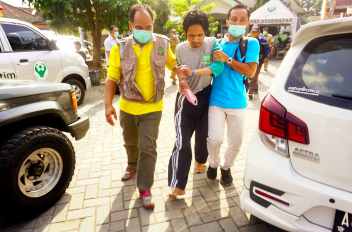Petugas membawa penderita gangguan jiwa (ODGJ) menuju bus yang menunggu di halaman kantor Dinas Kesehatan Tulungagung.