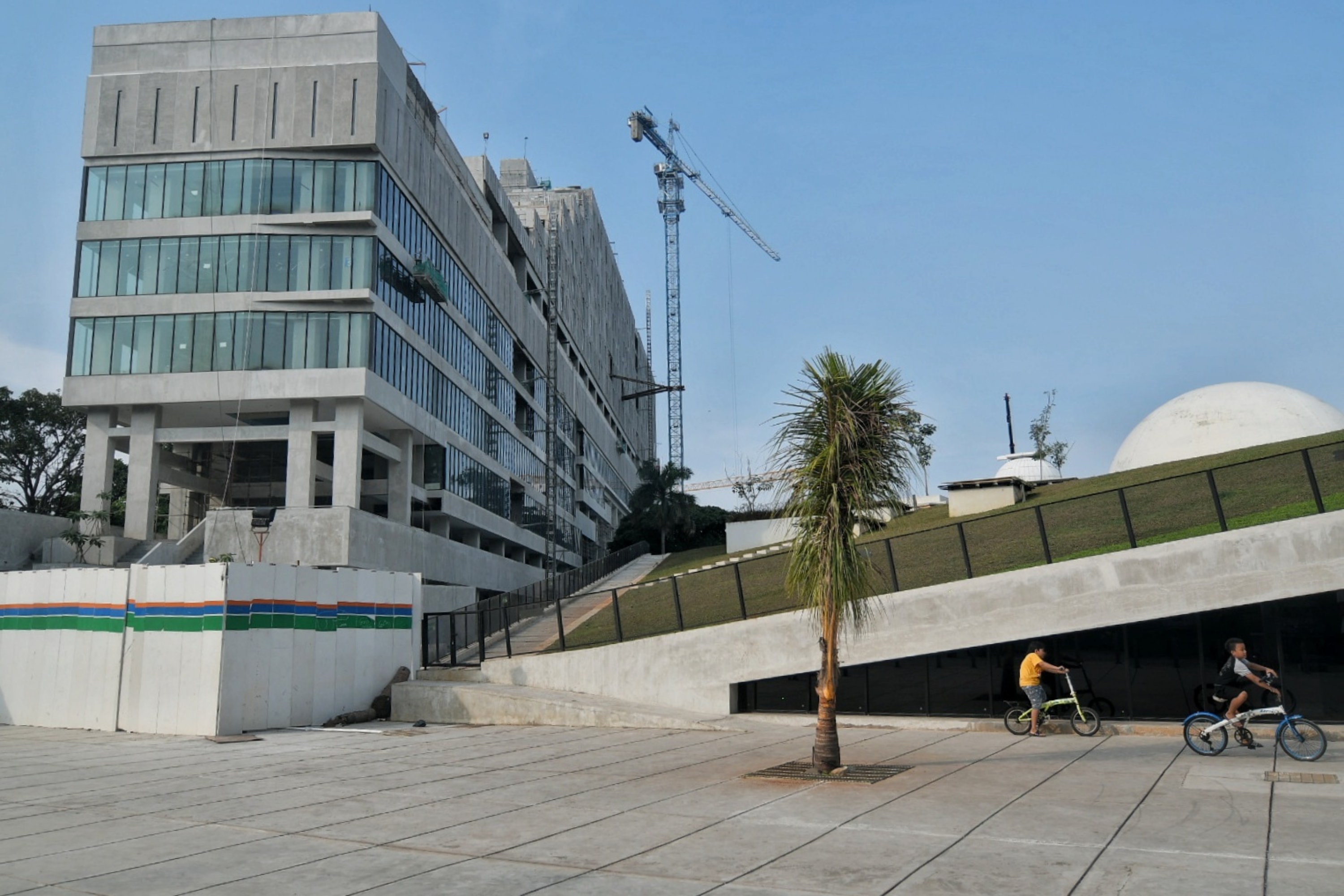 Anak-anak bermain di depan proyek revitalisasi Taman Ismail Marzuki di Cikini, Jakarta.