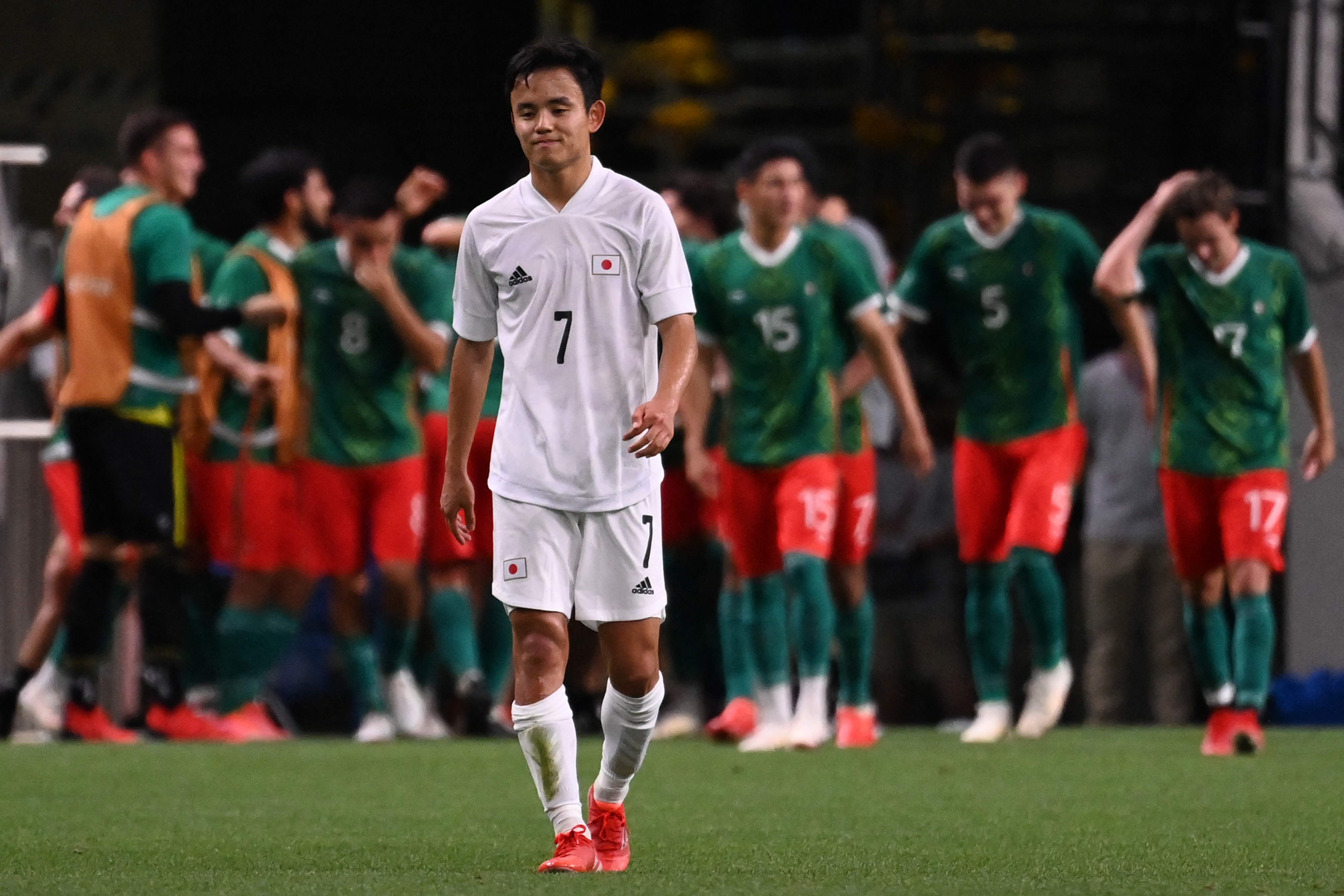 Pemain depan Jepang Takefusa Kubo berjalan dengan dilatari perayaan para pemain Meksiko