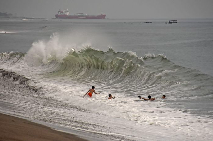 Anak-anak bermain di pantai saat terjadi gelombang tinggi di pantai Meninting, Kecamatan Batulayar, Lombok Barat, NTB, Sabtu (10/4/2021) .