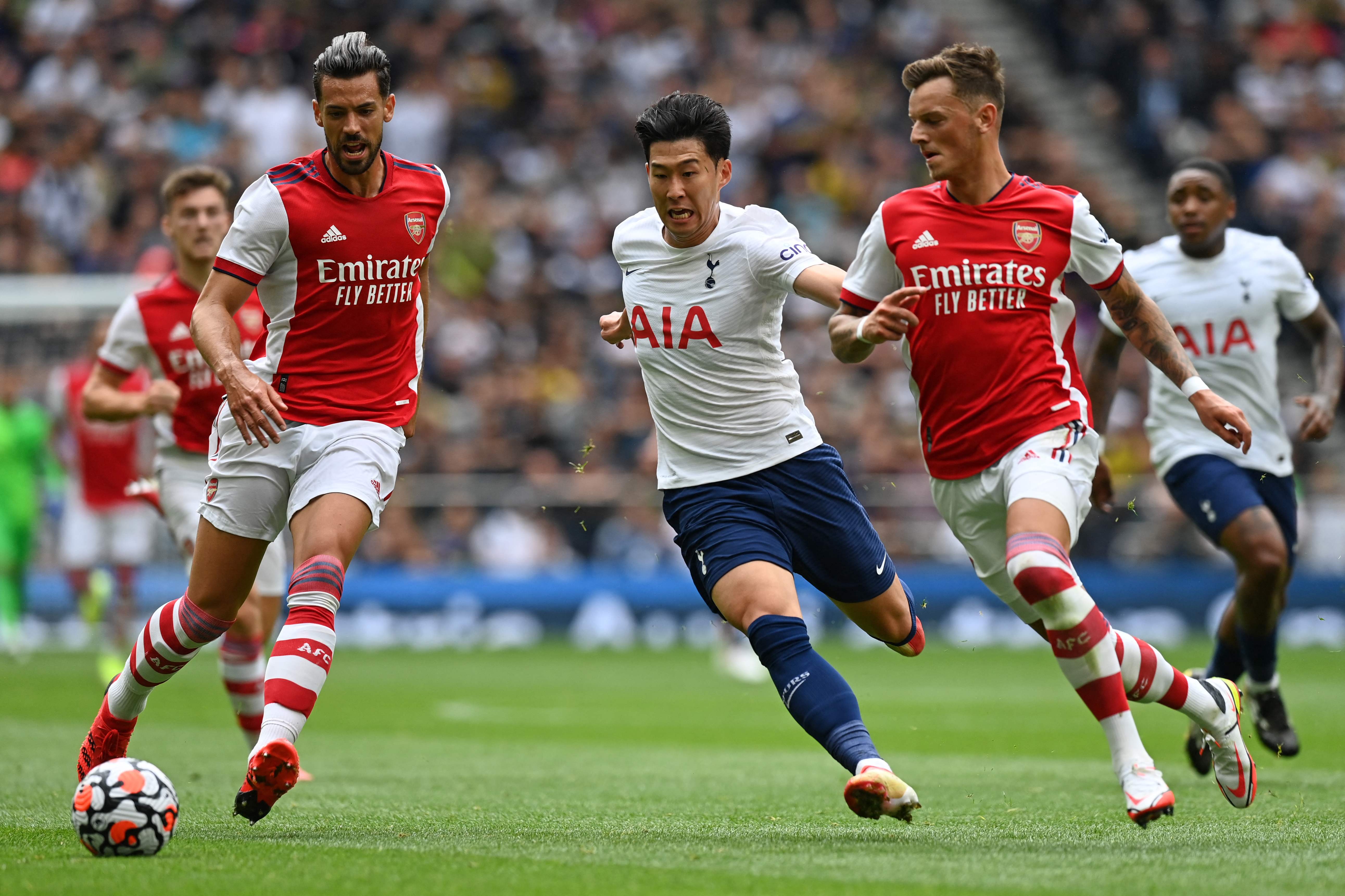 Penyerang Tottenham Hotspur Son Heung-min berusaha melewati hadangan dua pemain Arsenal di laga pramusim di London.