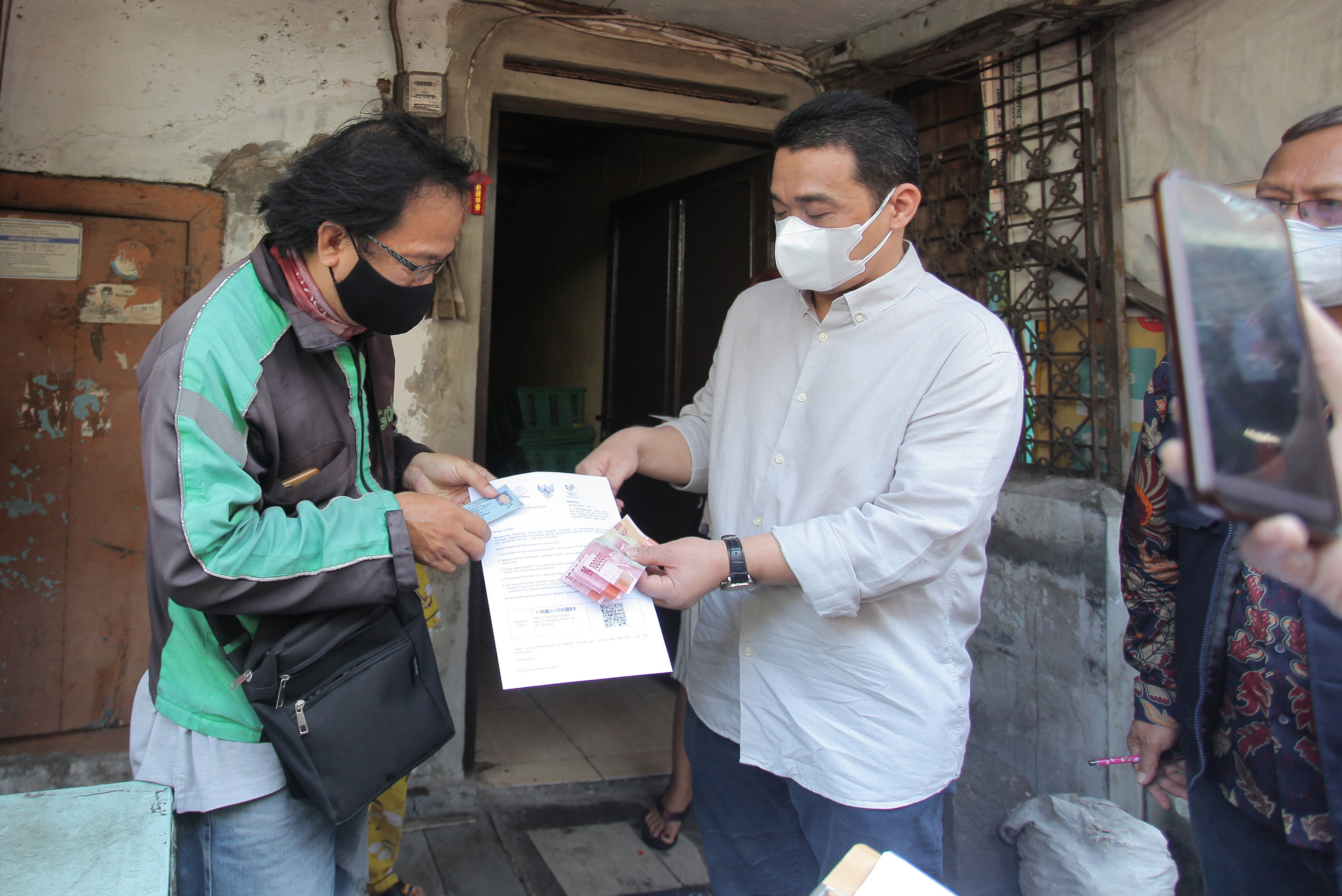 Wakil Gubernur DKI Ahmad Riza Patria saat mendistribusikan bansos tunai di Glodok, Jakarta.