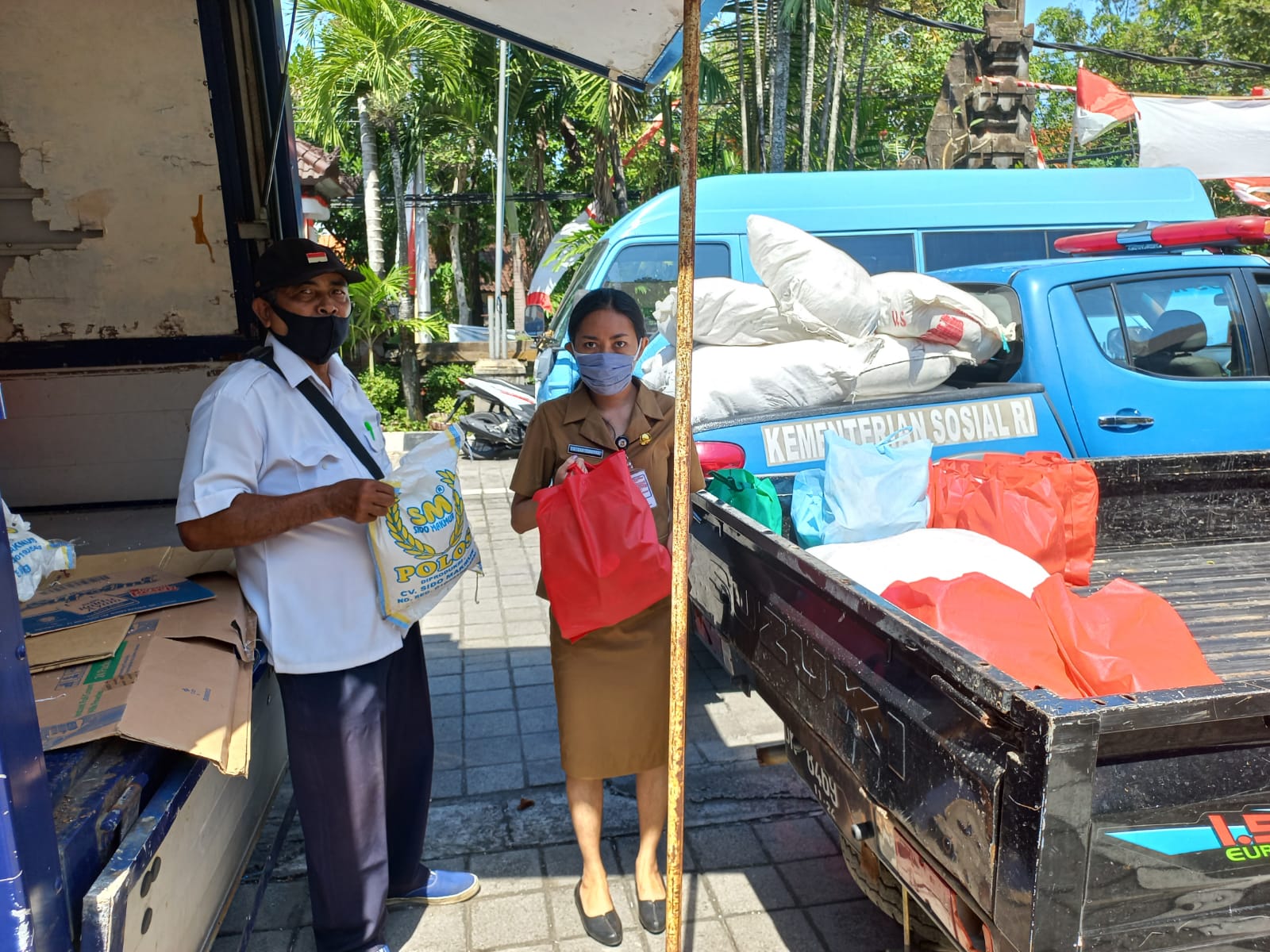 Petugas sedang menyalurkan paket sembako bagi warga yang menjalankan Isoman di Kota Denpasar, Senin (9/8).
