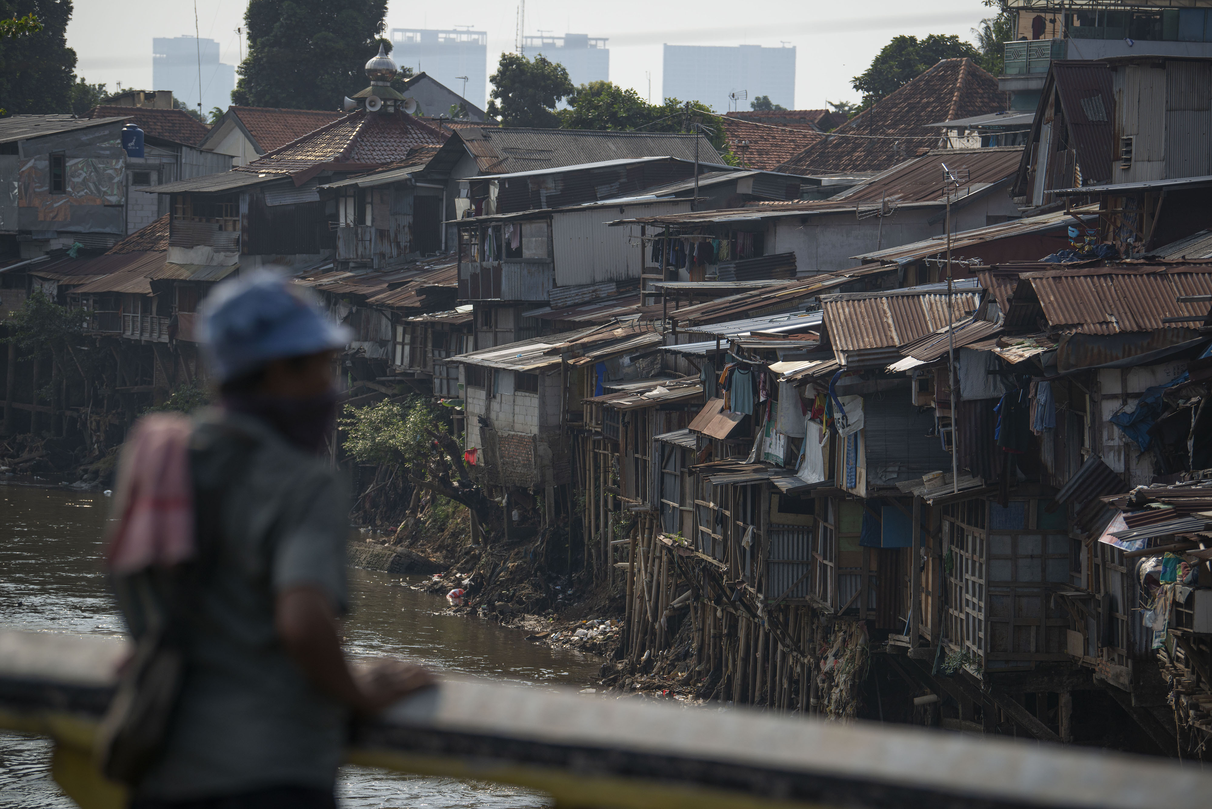 Warga memandang permukiman padat penduduk tepi Sungai Ciliwung di Kampung Melayu, Jakarta.