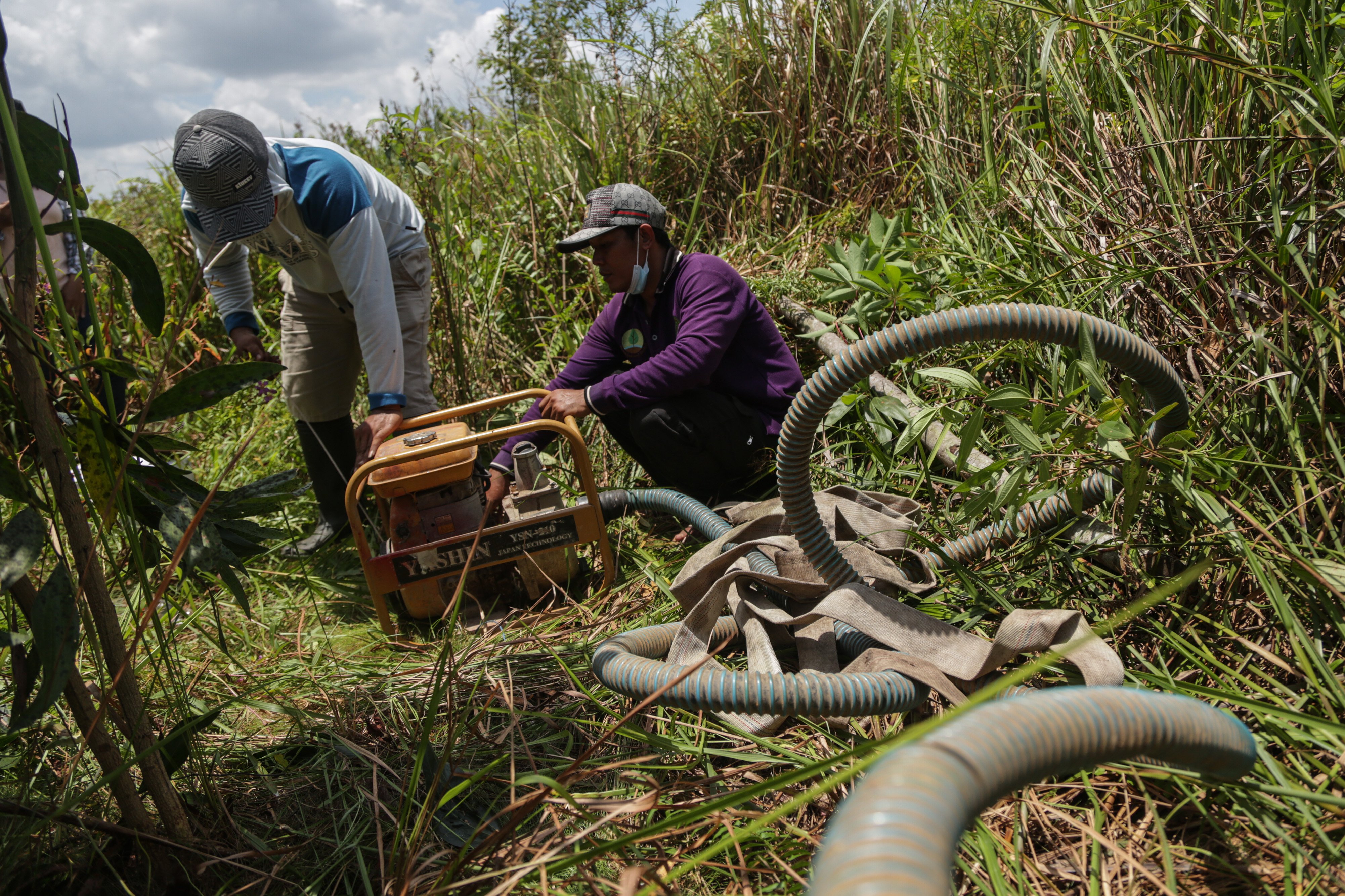 Masyarakat Peduli Api menyalakan pompa sebelum membasahi lahan gambut di Desa Talio Hulu, Kabupaten Pulang Pisau, Kalteng Minggu (19/9/2021)