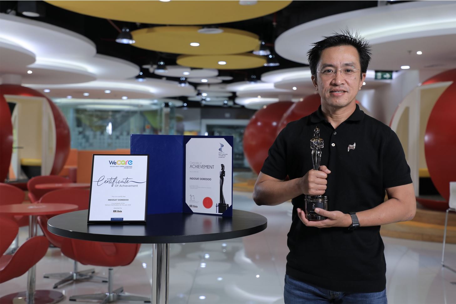 Director and Chief Human Resources Officer Indosat Ooredoo, Irsyad Sahroni menunjukkan penghargaan yang diterima perusahaan itu.